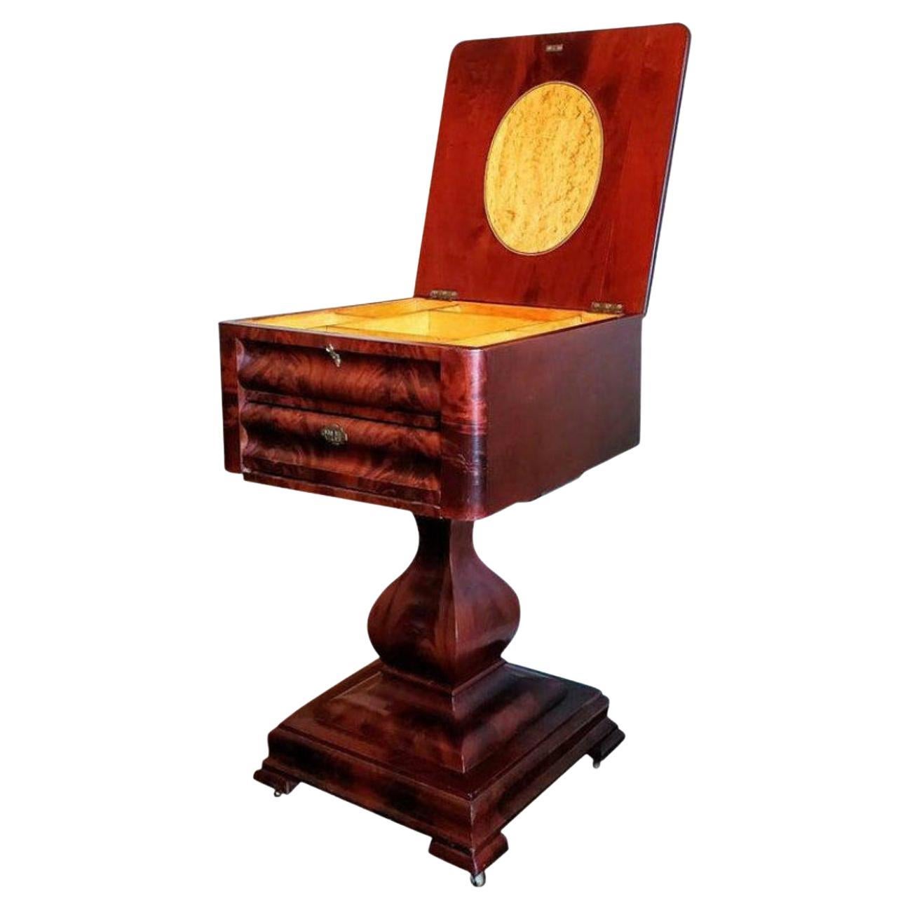 A rare fine quality Federal period American Empire flame mahogany sewing stand work table from the early 19th century.

Exquisitely hand-crafted in the northeastern United States, most likely Philadelphia, Pennsylvania, circa 1820, having a hinged
