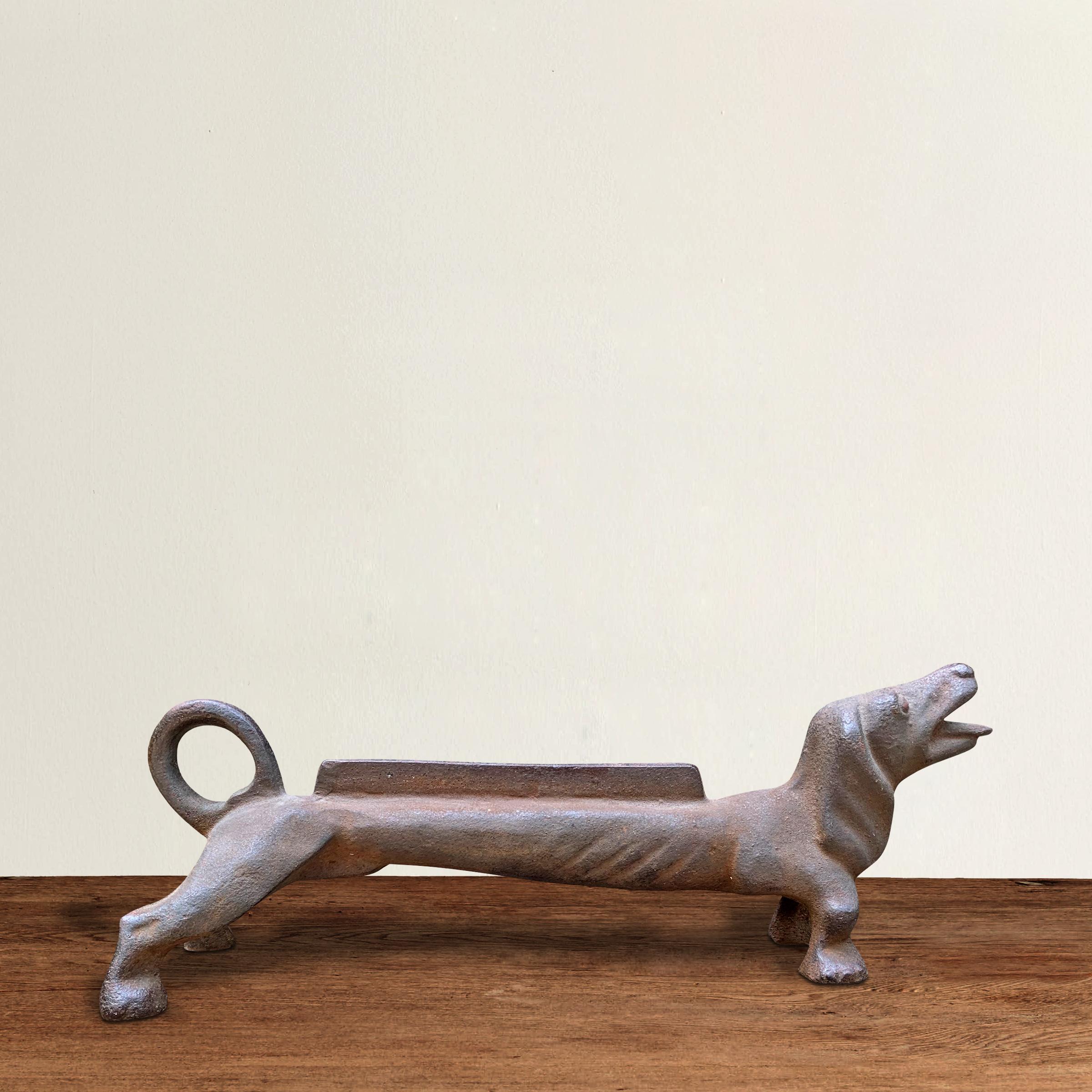 A whimsical late 19th century American cast iron dachshund boot scraper with an open mouth and sweet expression.
 