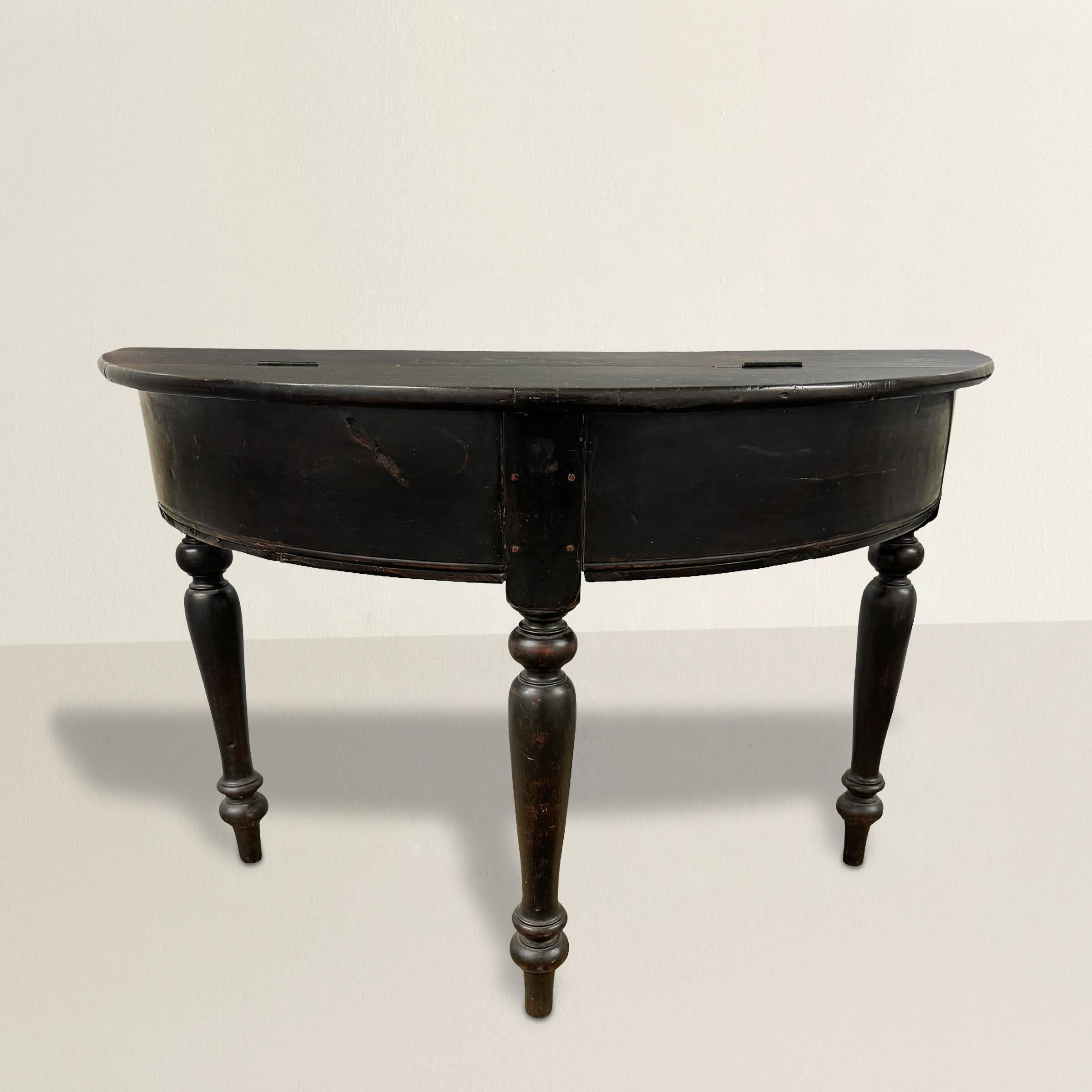 This 19th-century American demilune table is a charming blend of elegance and functionality. Its beautifully turned legs, ending with beaded feet, add a touch of sophistication to its simple yet chic design.

The table features a rather tall plain