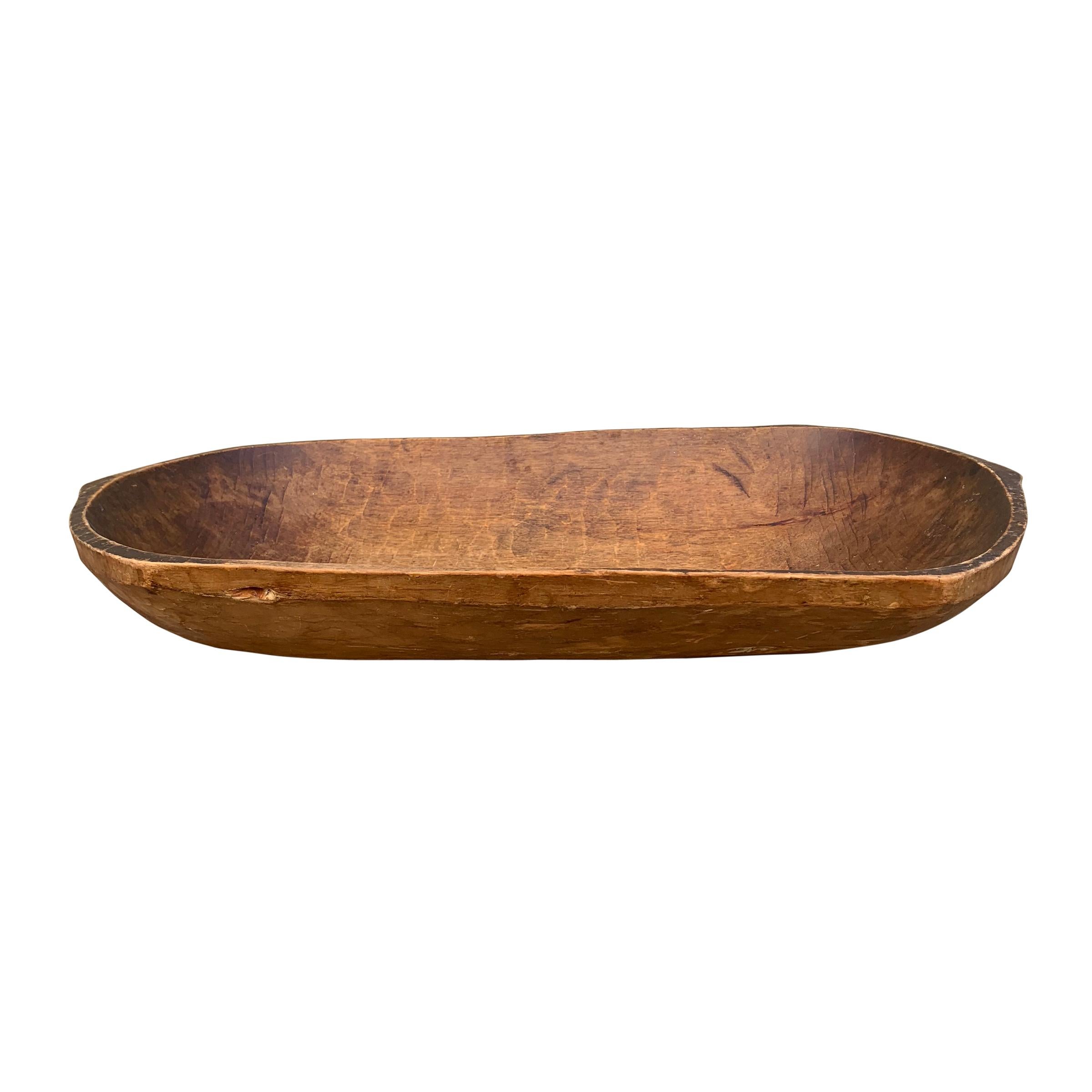 A gorgeous 19th century American hand carved wood dough bowl with pointed ends, and a wonderful patina.