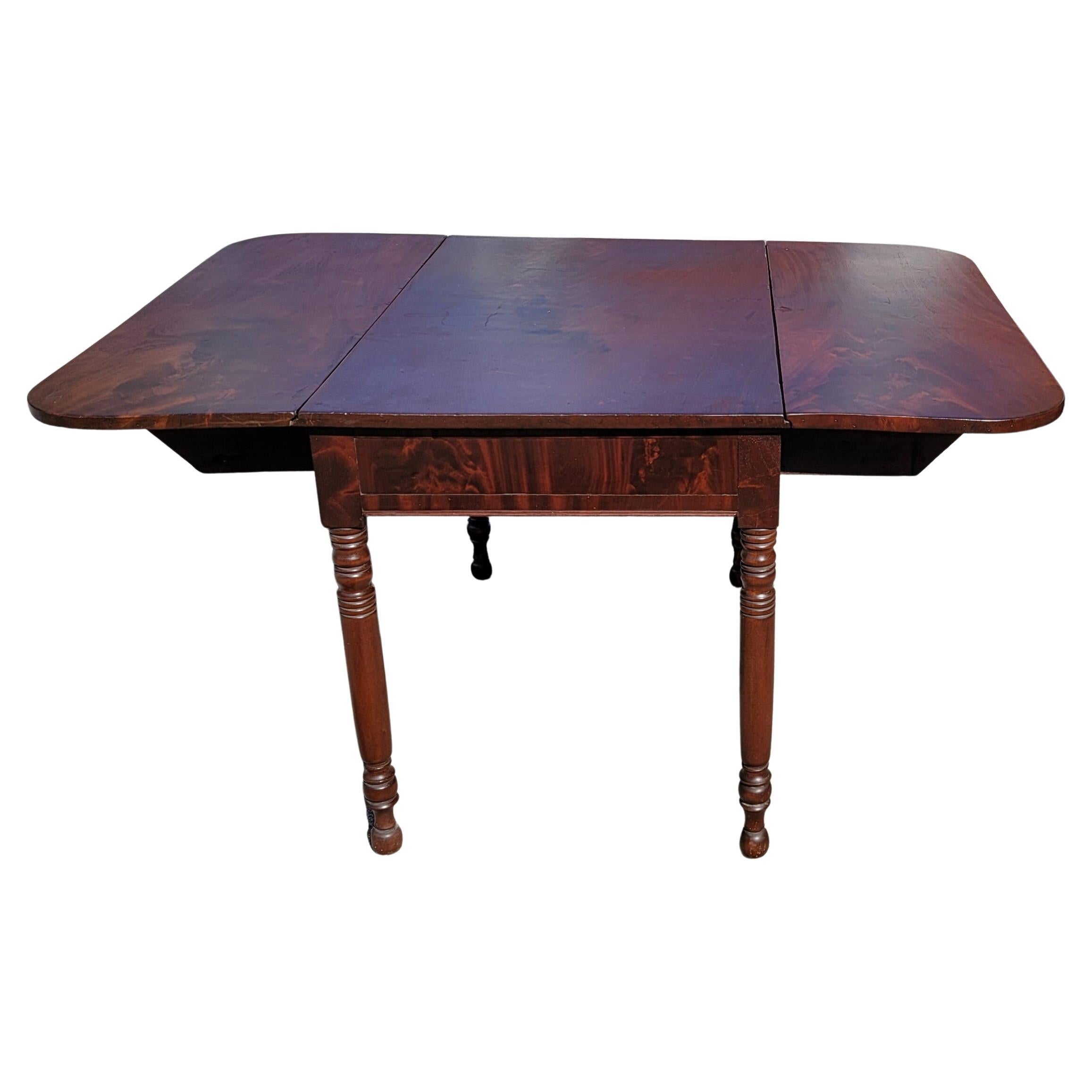 American, mid-19th century, Late Federal, American Empire flame mahogany drop-leaf dining table. Dining table is 40