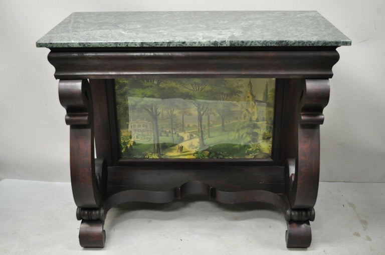 19th Century American empire mahogany green marble top console table. Item features green marble top, serpentine column supports, art print scene in glass, beautiful wood grain, very nice antique item. Circa late 19th century. Measurements: 34