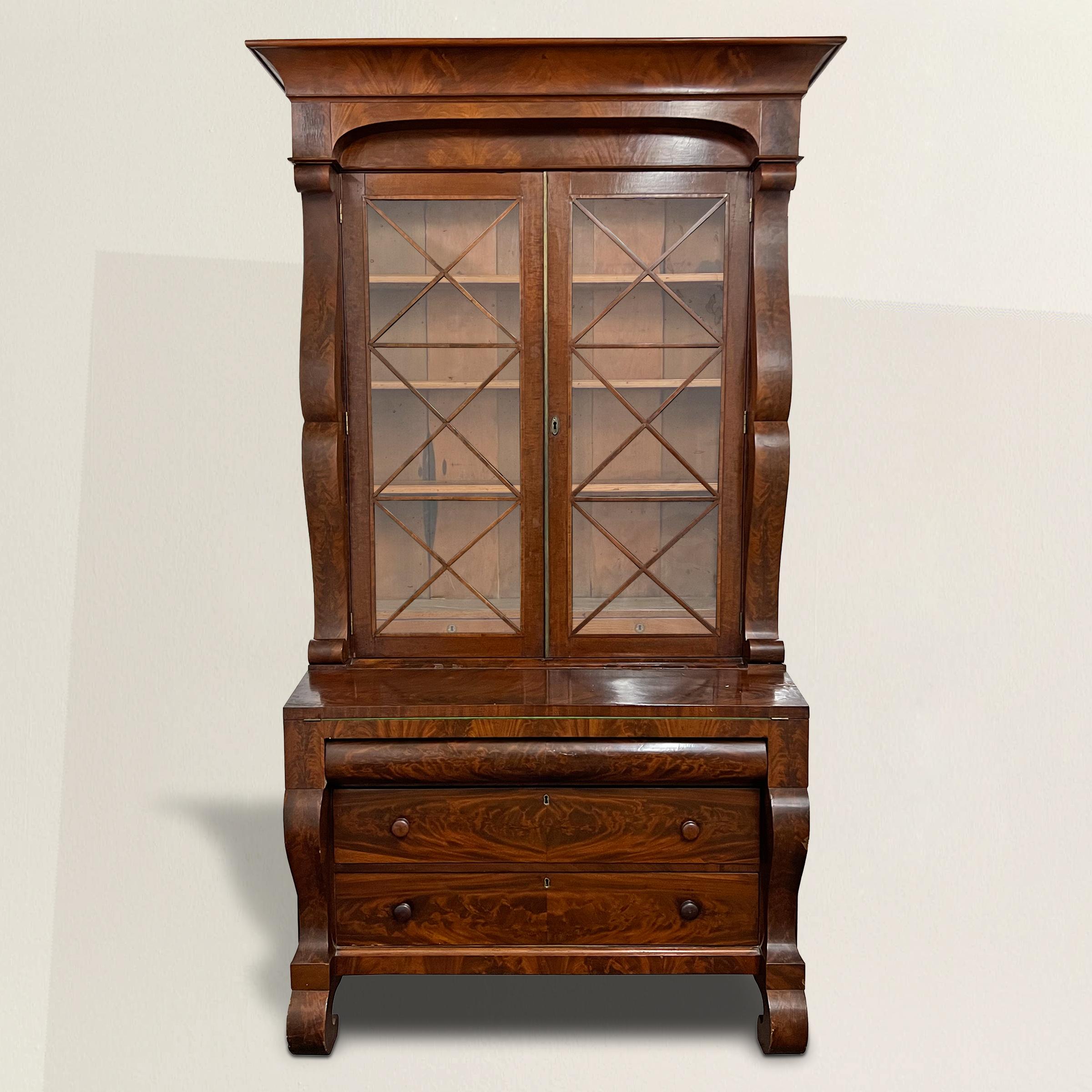 A remarkable, and strong early 19th century American Empire secretary bookcase of grand architectural scale with an incredible arched pediment over a bookcase with two doors retaining their original wavy glazing, three adjustable interior shelves