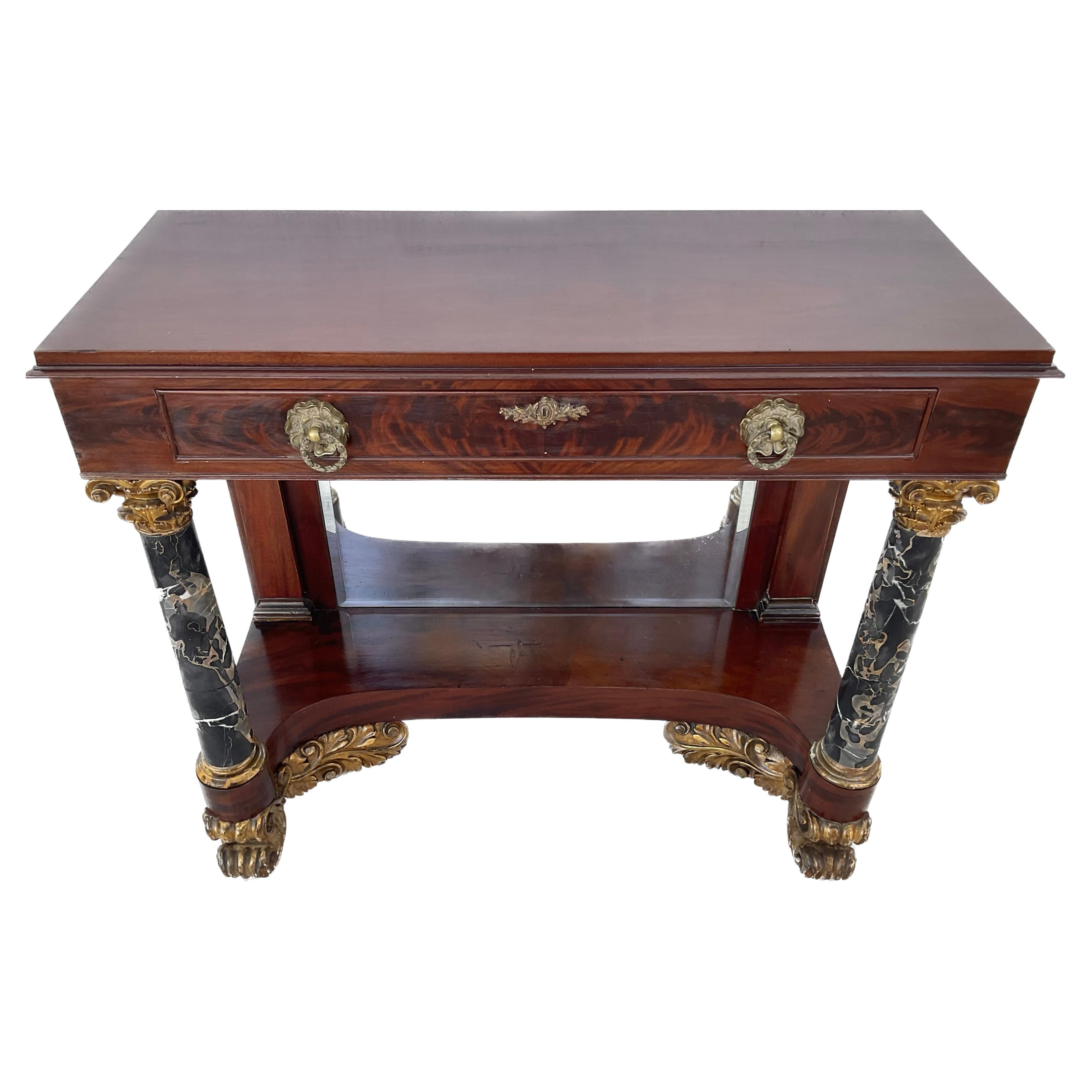Handsome 19th century Federal period mahogany pier or console table. The table front is accented by ormolu rosettes and foliage decoration. Table features two front black and white swirled Portoro marble columns topped by gilt ormolu floral