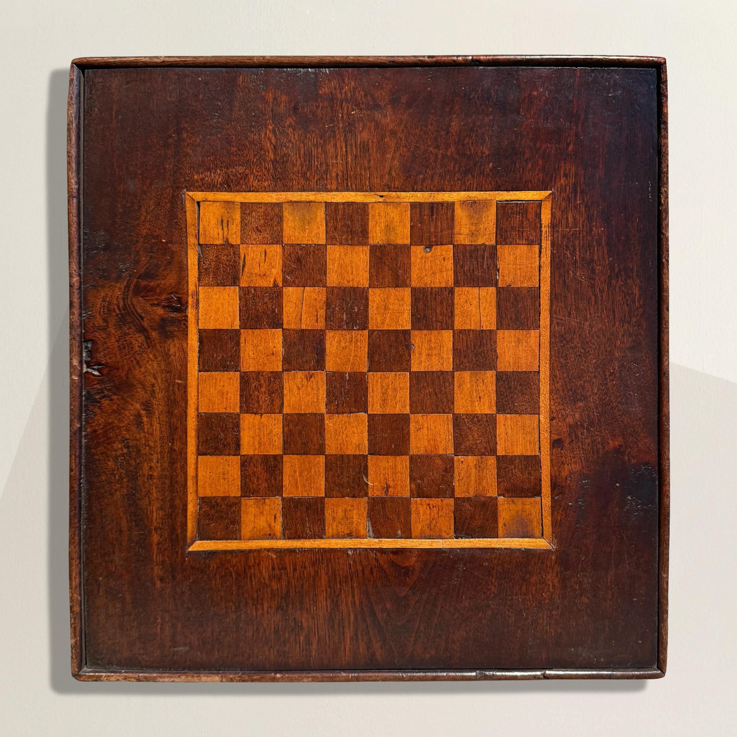 Beautifully hand-crafted and quietly sculptural, this 19th-century American Folk Art game board was made not in a factory, but by someone who clearly knew their way around a piece of wood. Sixty-four walnut and maple squares form the playing field,