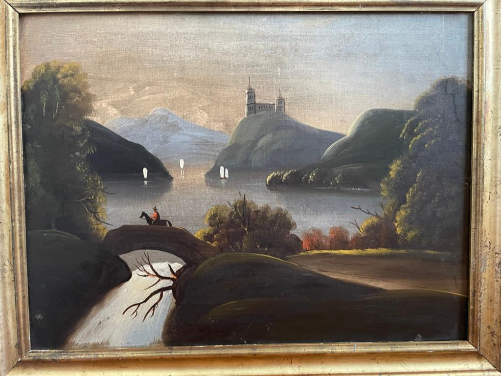 A 19th century American folk art oil painting on canvas depicting a river scene at dawn with a horse and rider on a bridge over a waterfall. A castle in the distance and sailboats on the water. The primitive style and naive perspective give this