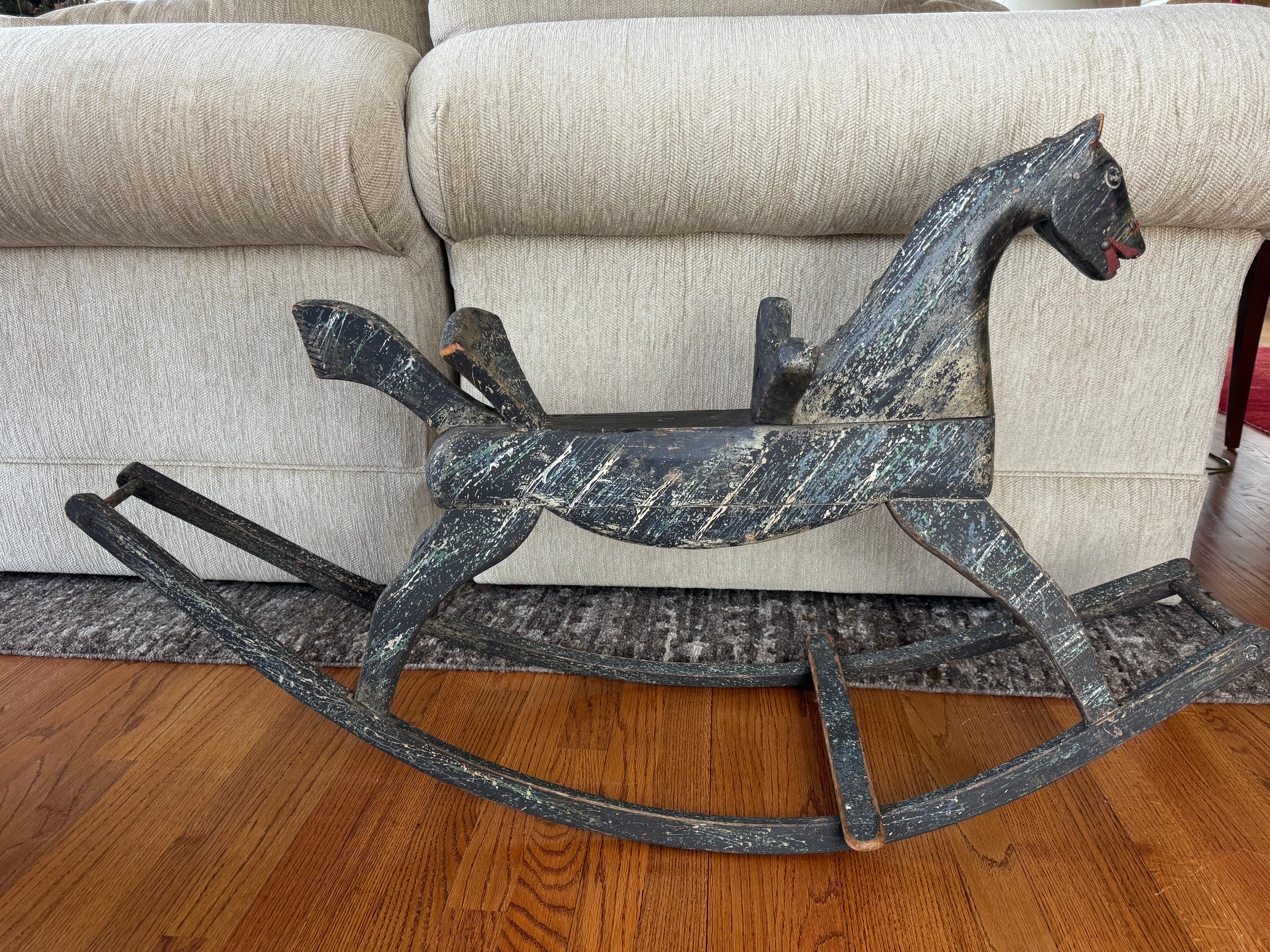 Charmant et expressif cheval à bascule en bois sculpté du XIXe siècle, dont la surface peinte à l'origine présente une belle patine d'usure. La forme allongée et stylisée est sculptée à la main avec des caractéristiques exagérées - un cou arqué, des