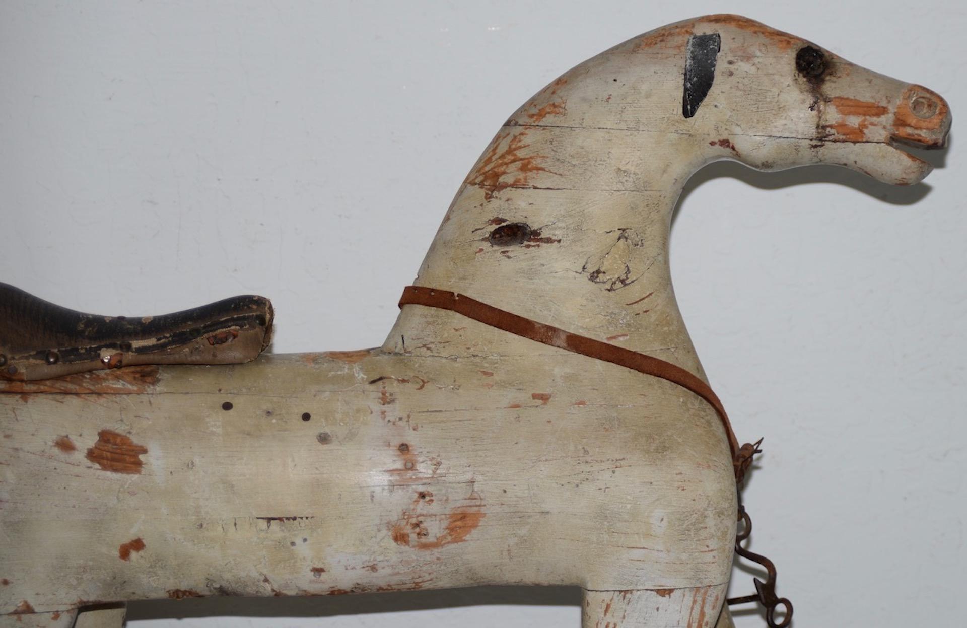 19th century American Folk Art rocking horse

Fantastic American Folk Art hand carved rocking horse with ample remains of red and white paint.

The horse has leather ears and saddle. One eye is yellow glass, the other is missing. The horse has a