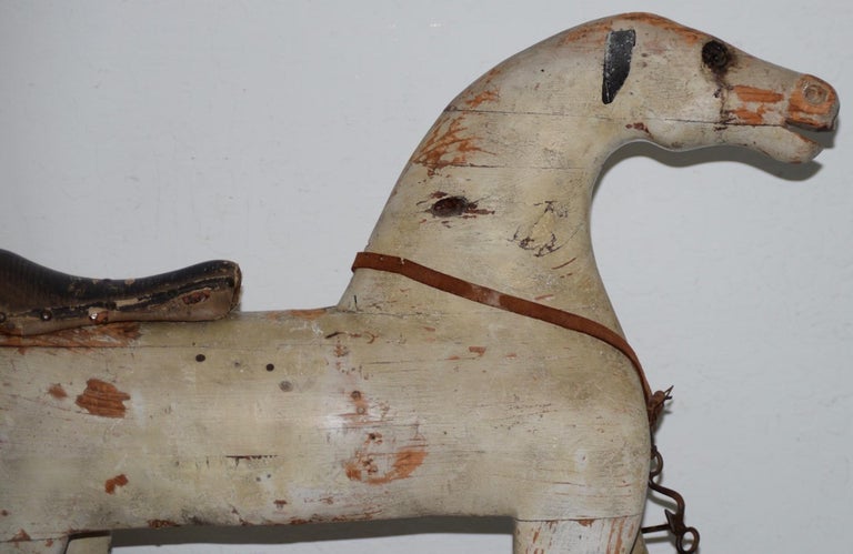 19th century American Folk Art rocking horse

Fantastic American Folk Art hand carved rocking horse with ample remains of red and white paint.

The horse has leather ears and saddle. One eye is yellow glass, the other is missing. The horse has a