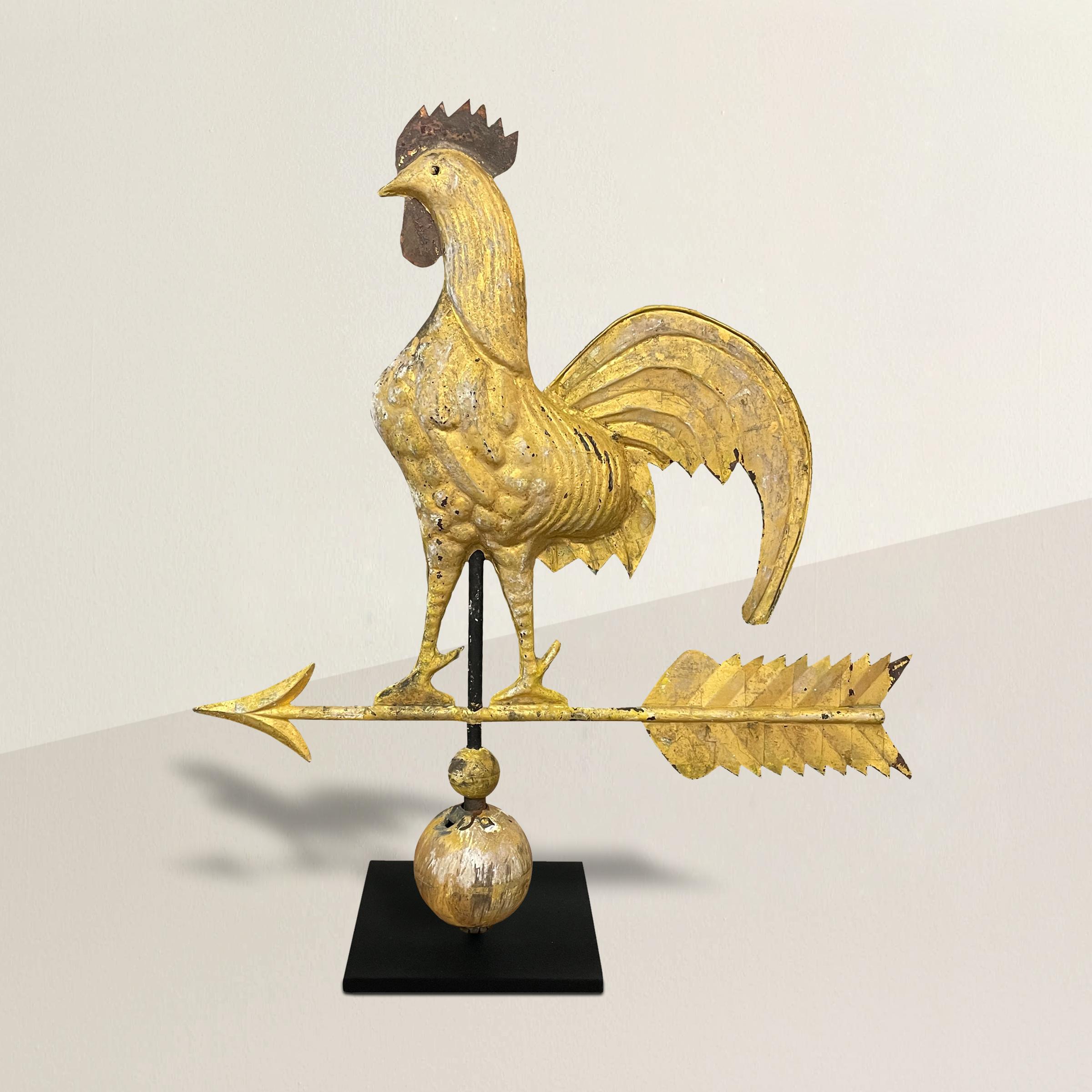 A charming bucolic 19th century American gilt and painted copper weathervane depicting a hollow-bodied rooster with painted comb and wattle, large flowing crimped tail feathers, and standing on an arrow. Mounted on a custom steel stand. Can't you