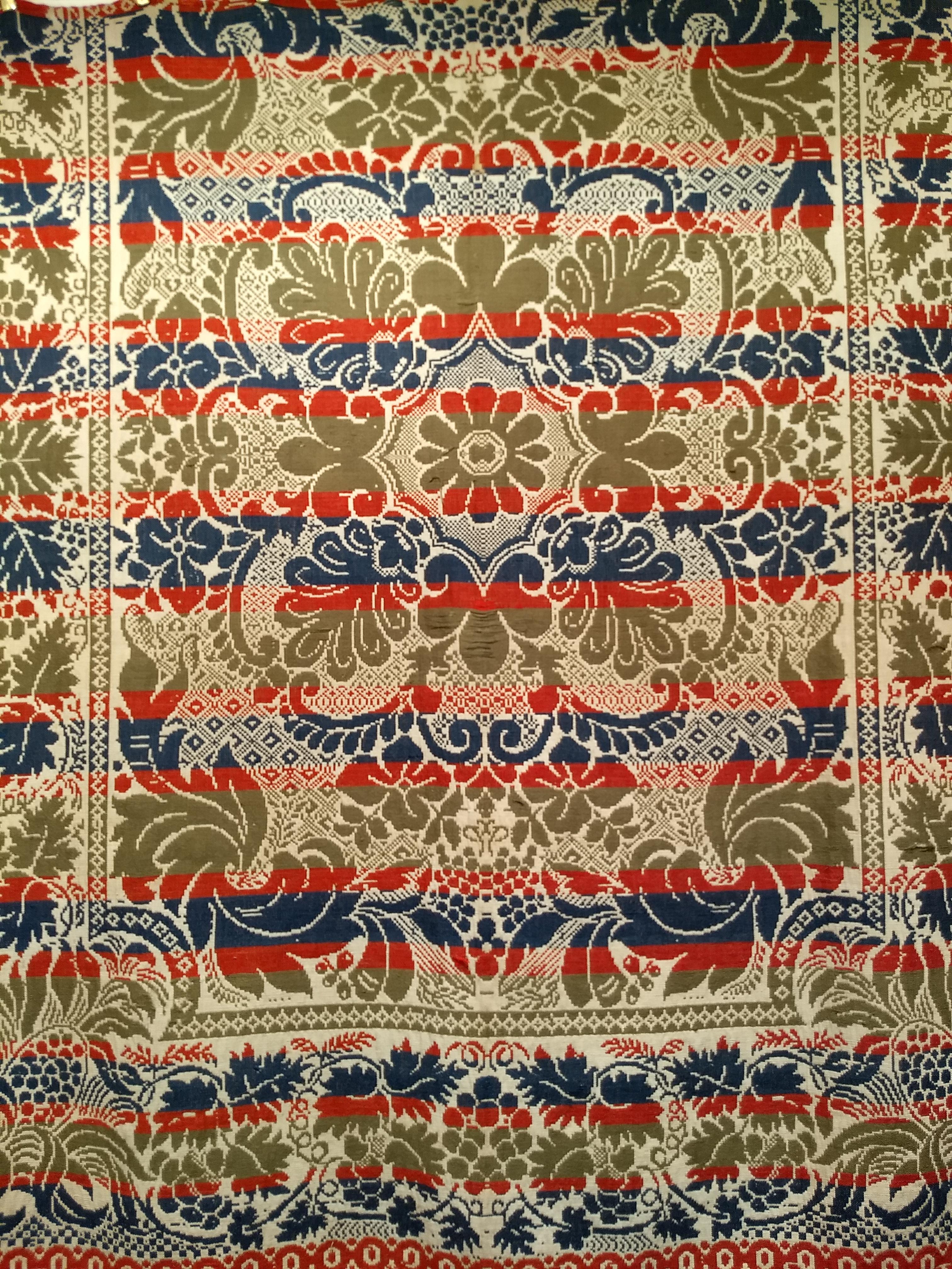 A beautiful Pennsylvania American Coverlet from the mid 1800s.  The American Coverlet has large format floral design in red, blue and green set on an ivory color background.  The American coverlets became very popular during the early to mid part of
