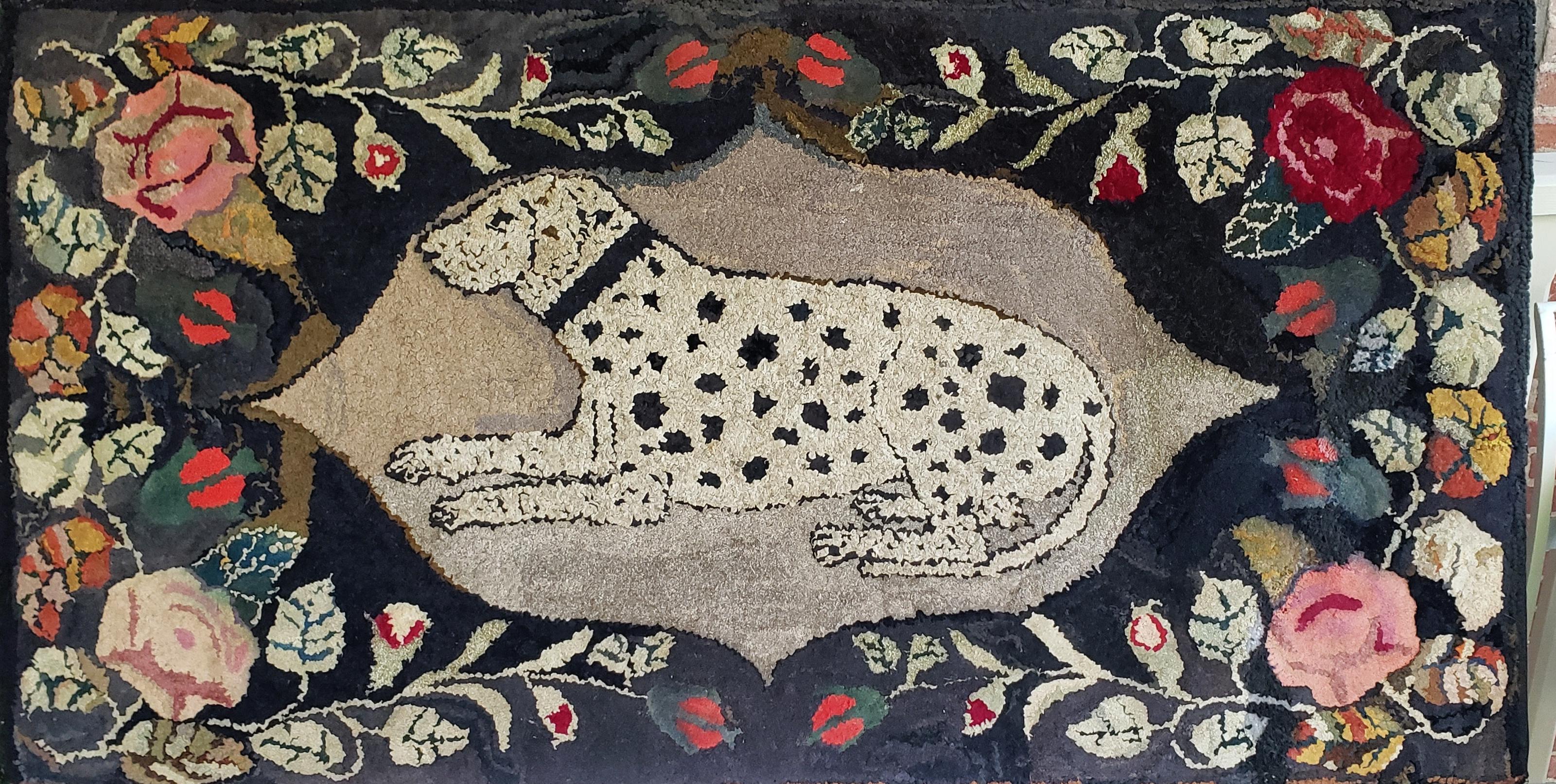 Hooked and shirred hearth rug, New England, circa 1850s in wool, cotton and linen. This dramatic folk art piece is in excellent condition. 
Depicting a recumbent dalmatian surrounded by bright beautiful garlands of flowers all on a wonderfully