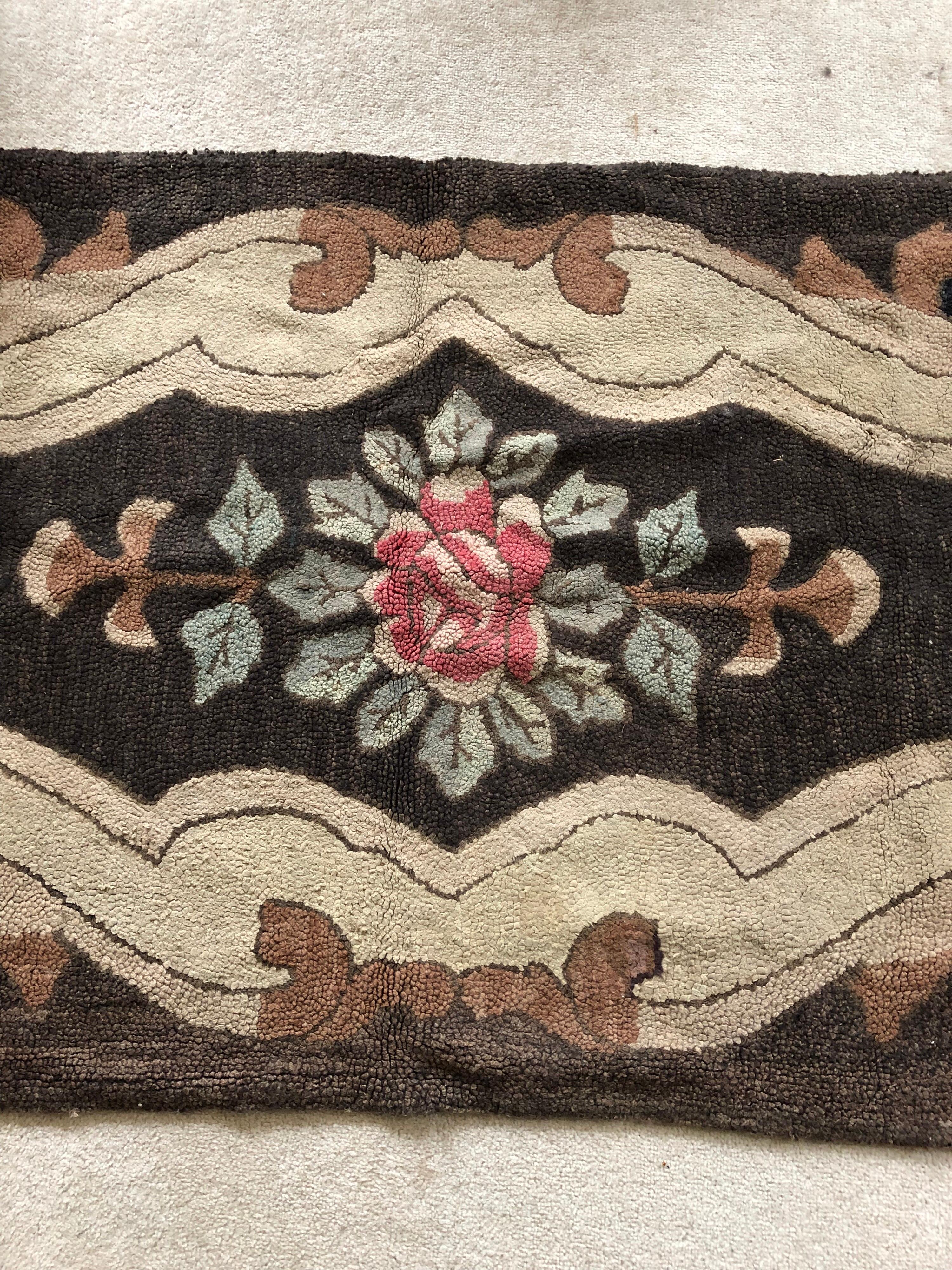 Whimsical 19th century American hooked rug, probably from New England. Hand knotted. Burlap backing. Floral medallion surrounded by swirls.