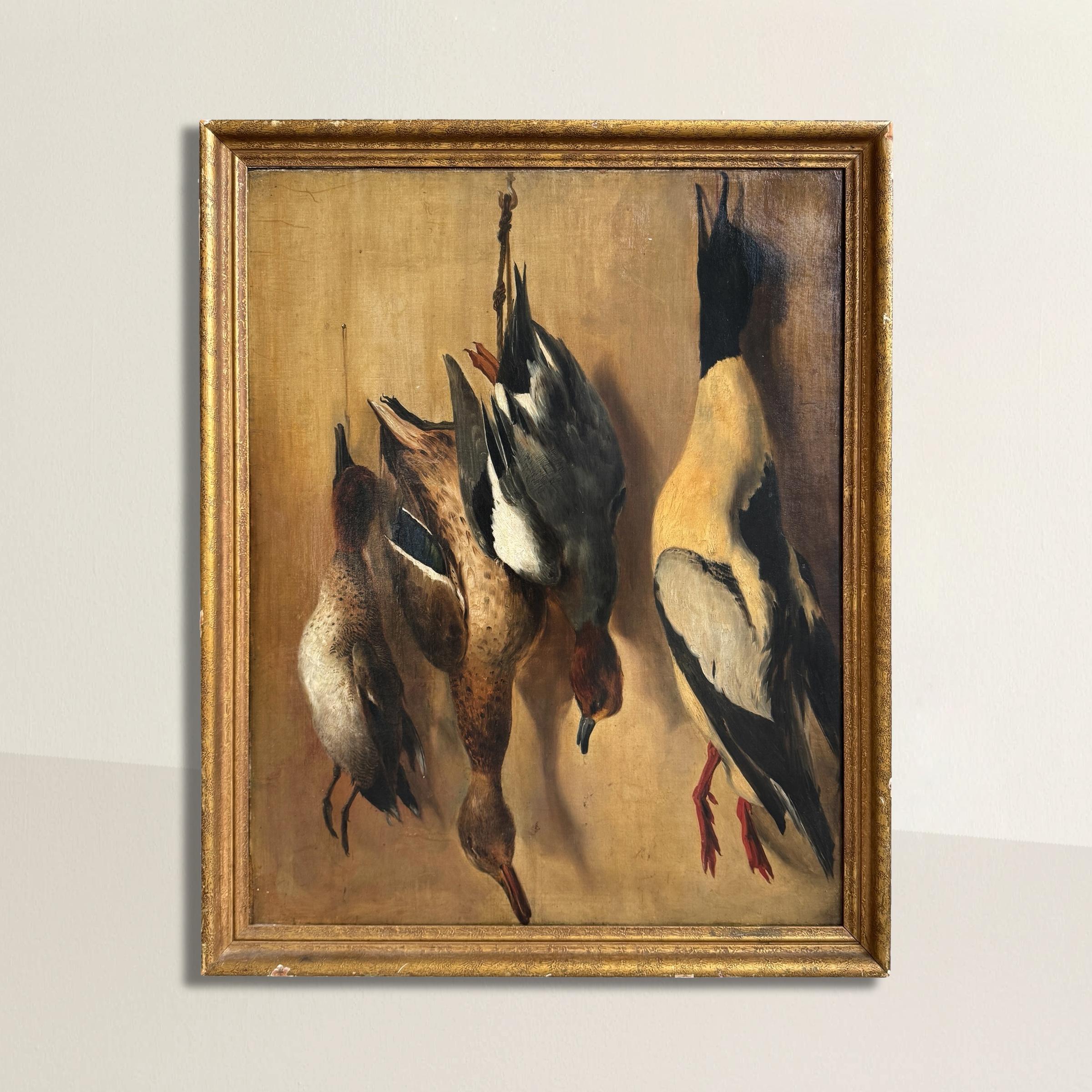 A striking 19th-century American oil on canvas, this still life captures a huntsman’s trophies in exquisite detail. A large Common Merganser drake, two female Mergansers, and a female Mallard hang lifeless from their lanyards against a boldly