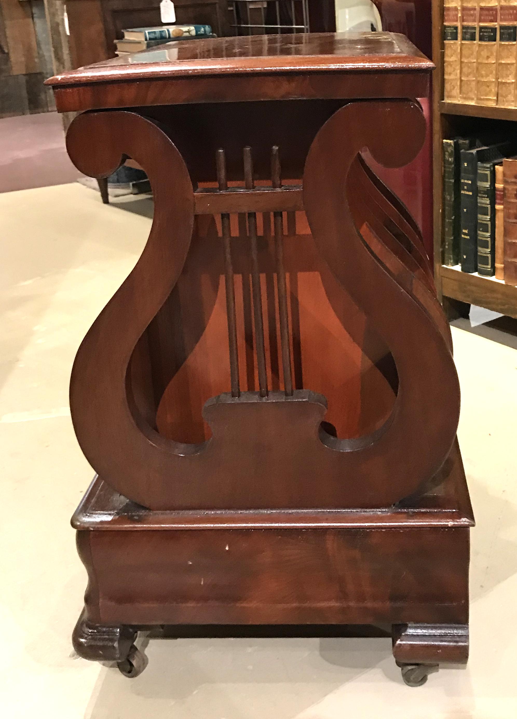 A fine mahogany lyre form Canterbury for sheet music with brass casters. American, dating to the 19th century, in very good overall condition, with a few surface rubs, scratches, and expected wear from age and use. Dimensions: 23 in H x 18 in W x