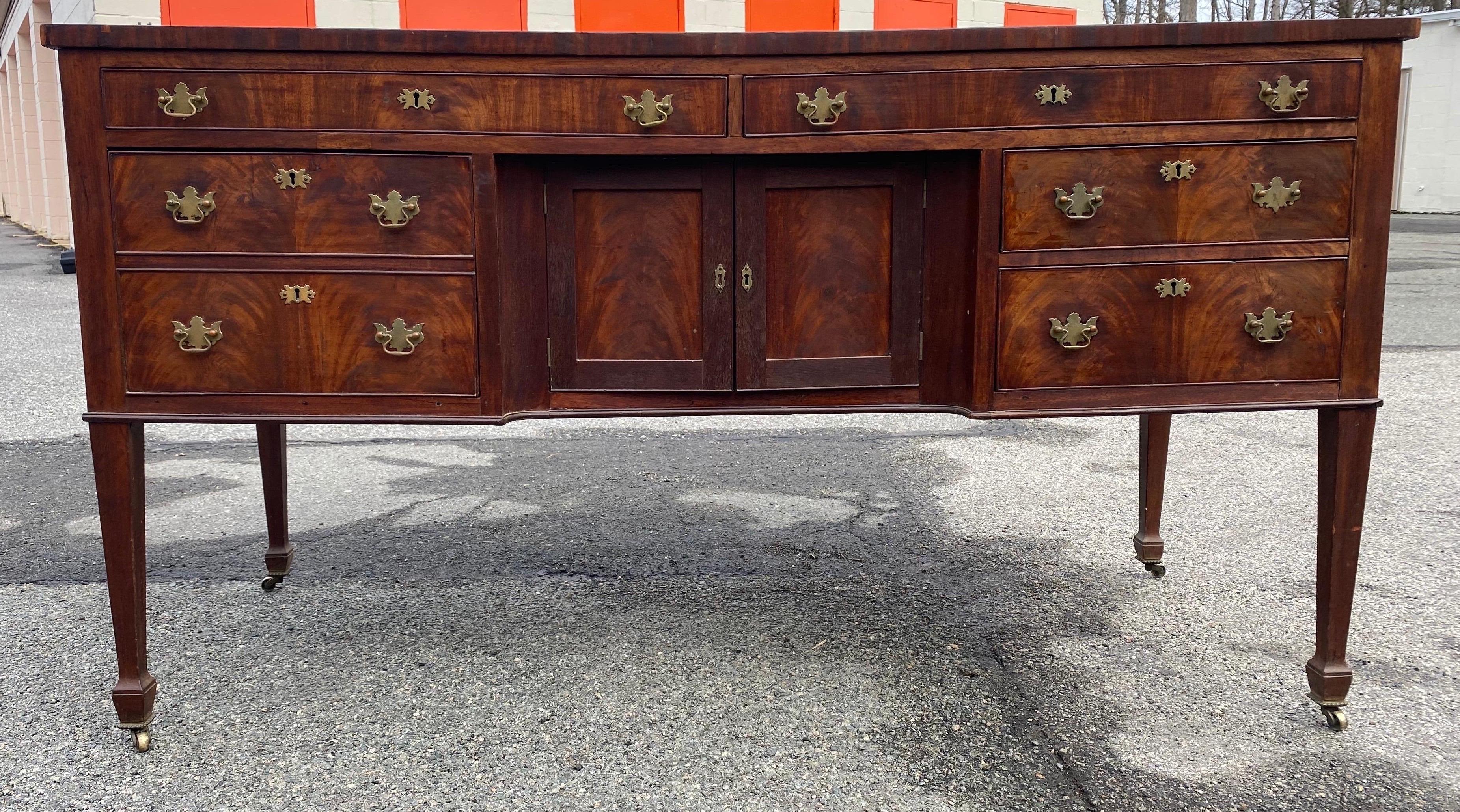 19th century American mahogany sideboard on tapered legs. Two drawers over cabinet doors which are flanked by a fitted double drawer on the left and two regular drawers on the right. Nice depth and color.
