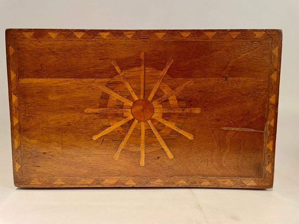 19th Century American sailor made nautical themed inlaid ships wheel on the top, also called the helm. The front, sides and back are inlaid with geometric circular star patterns. Interior and exterior borders inlaid with geometric designs in various