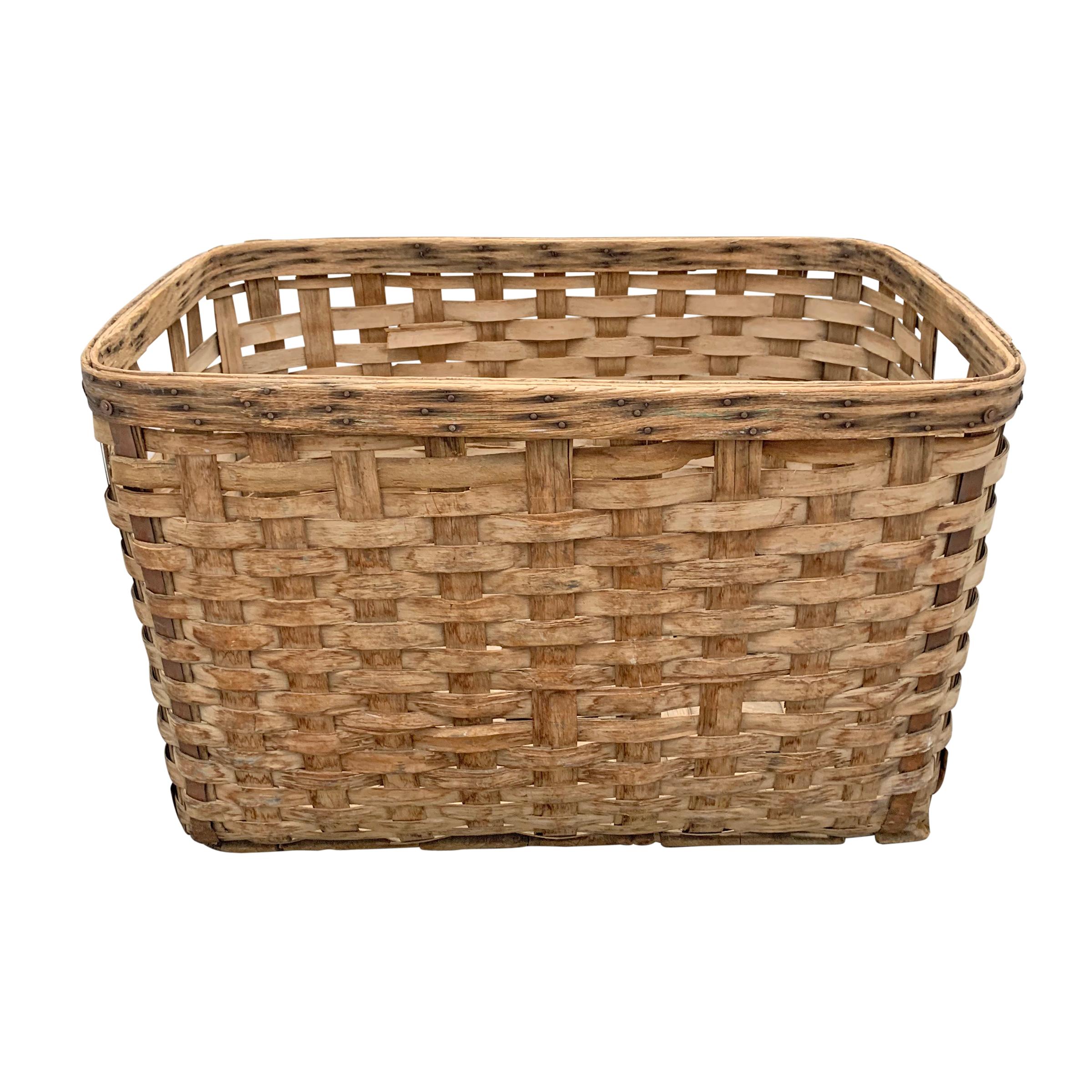 A large 19th century American oak splint shipping basket with a heavy double-banded rim, iron reinforcements on each corner, and two wooden runners across the bottom, all for added stability in shipping. Perfect for firewood, dogs toys, or anything
