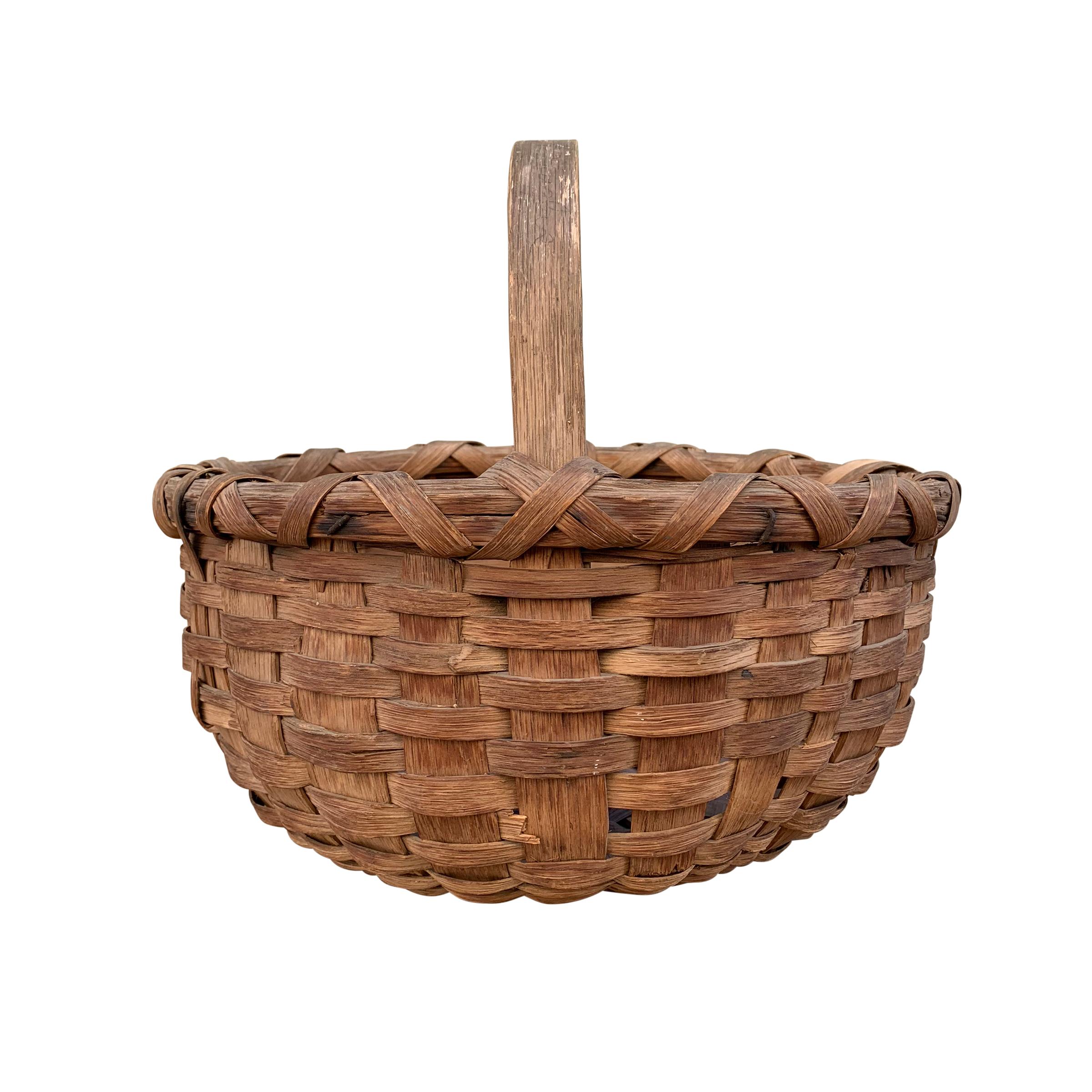 A beautiful 19th century American oak splint gathering basket with a bentwood handle and a double-banded rim. Gathering baskets like this were used to gather fruits, vegetables, flowers, and eggs from the farm.