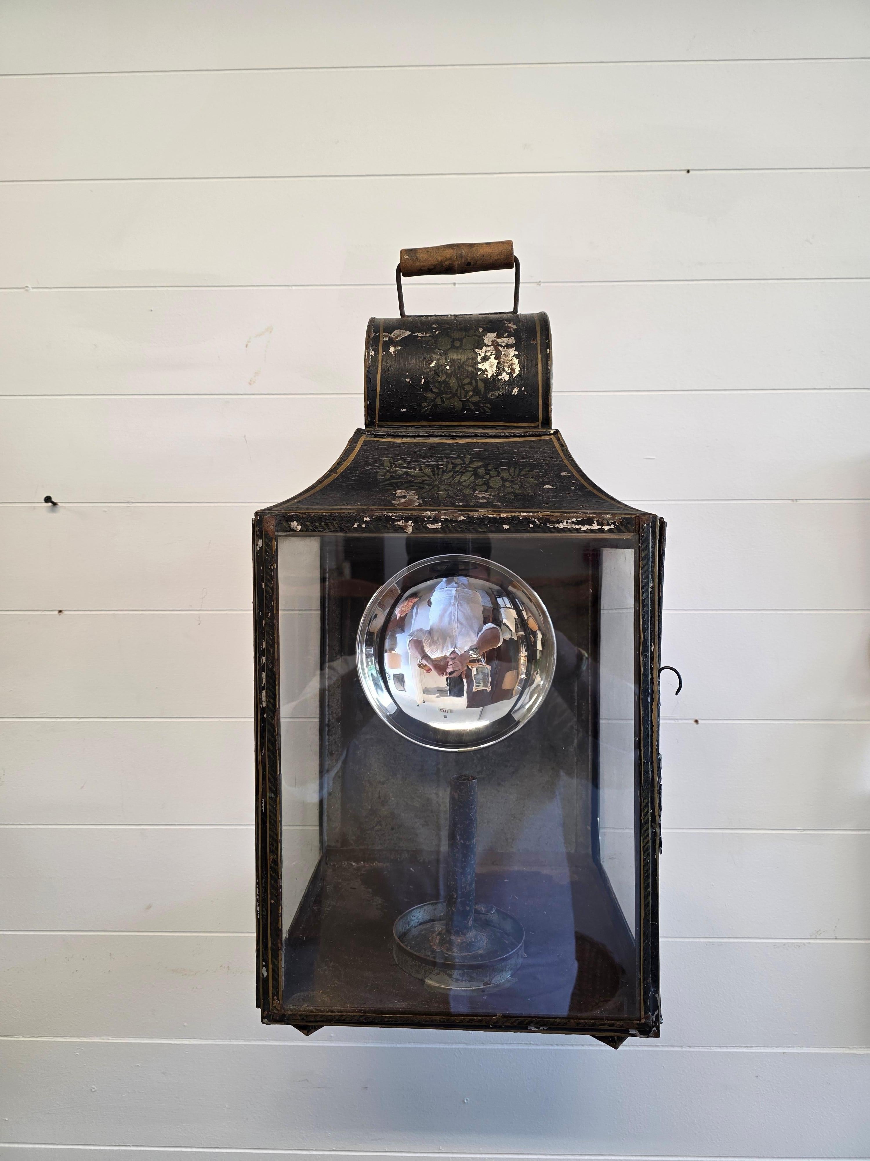 A very handsome and well patented painted tole lantern. Retaining all of the original surface with no touched up details. The interior with the original Mercury glass refractor and tole candle holder. This item is both hand-painted and hand