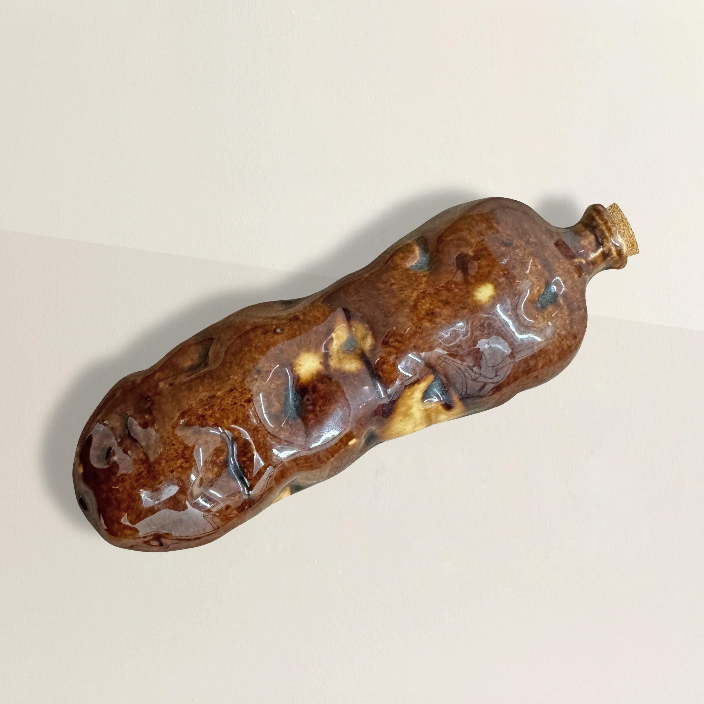 Cette gourde américaine en grès Rockinghamware du milieu du 19e siècle est un clin d'œil charmant à la fantaisie et à l'aspect pratique. En forme d'humble pomme de terre, il s'agit d'une relique rare et ludique des années 1850-60, conçue pour boire