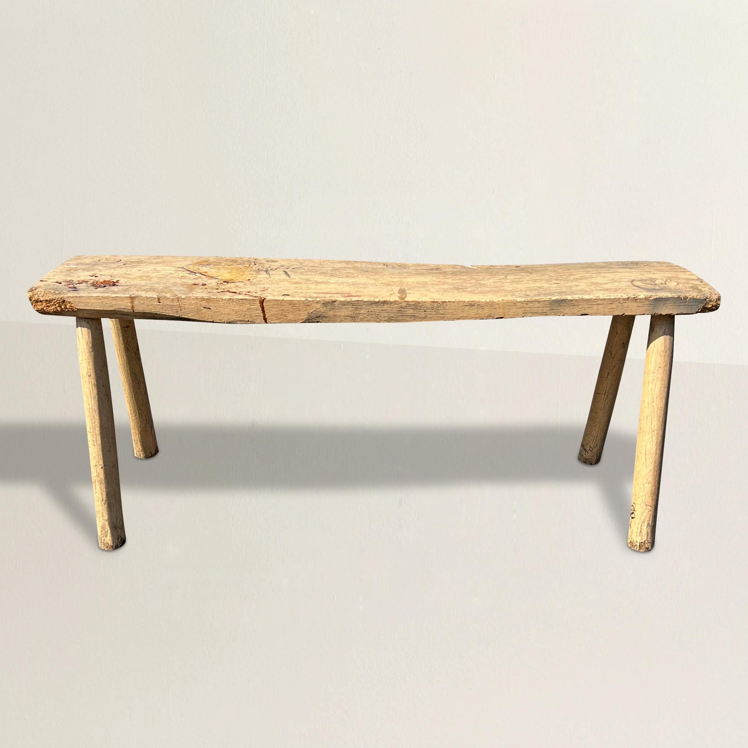 Transport yourself back to the 19th century with this charming American primitive bench, a testament to simplicity and functionality. Crafted with a minimalist design, it boasts four sturdy pegged legs that provide stability and durability. Its