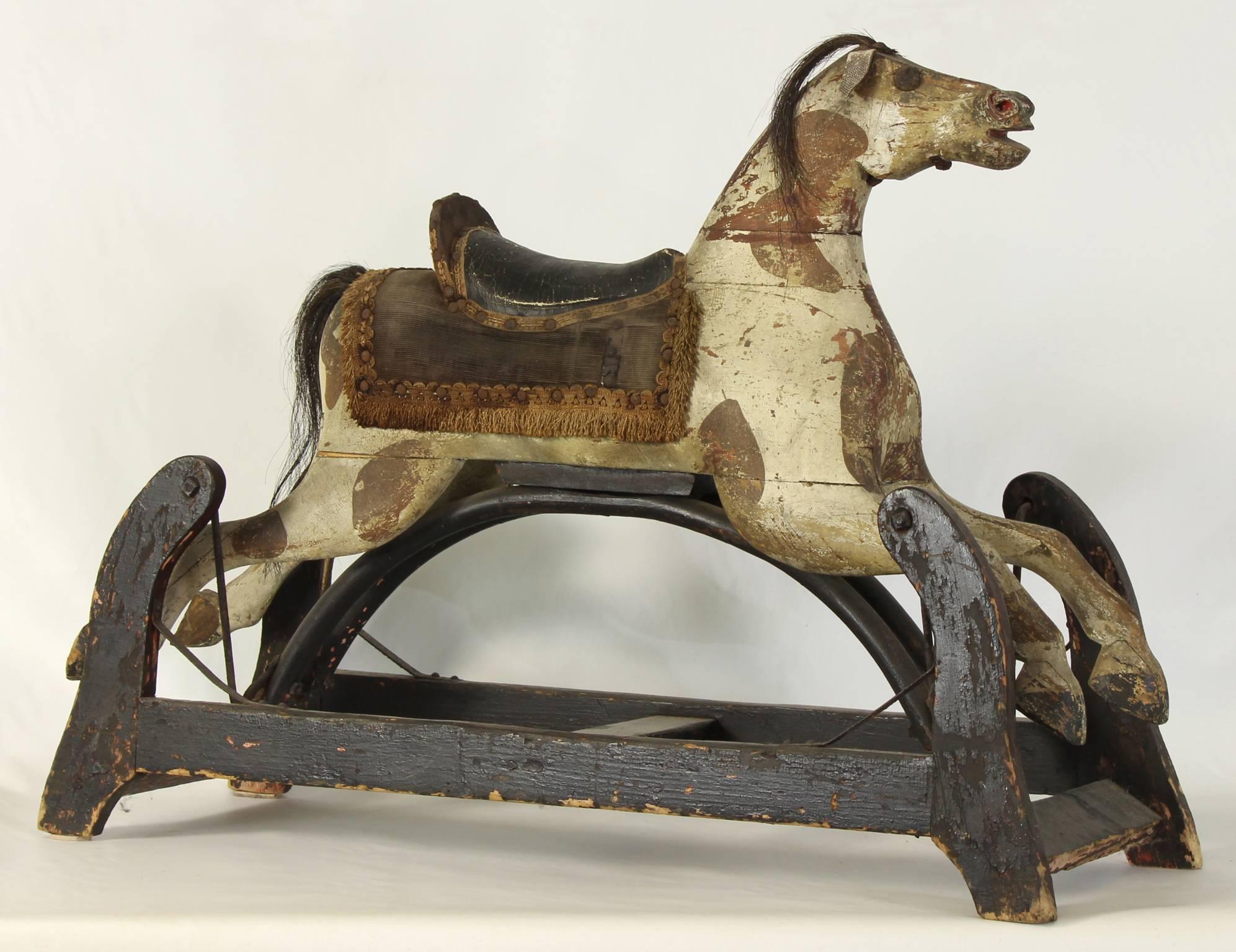 A wonderful and whimsical, late 19th century American child's rocking horse complete with original paint decoration, horsehair main and leather saddle.