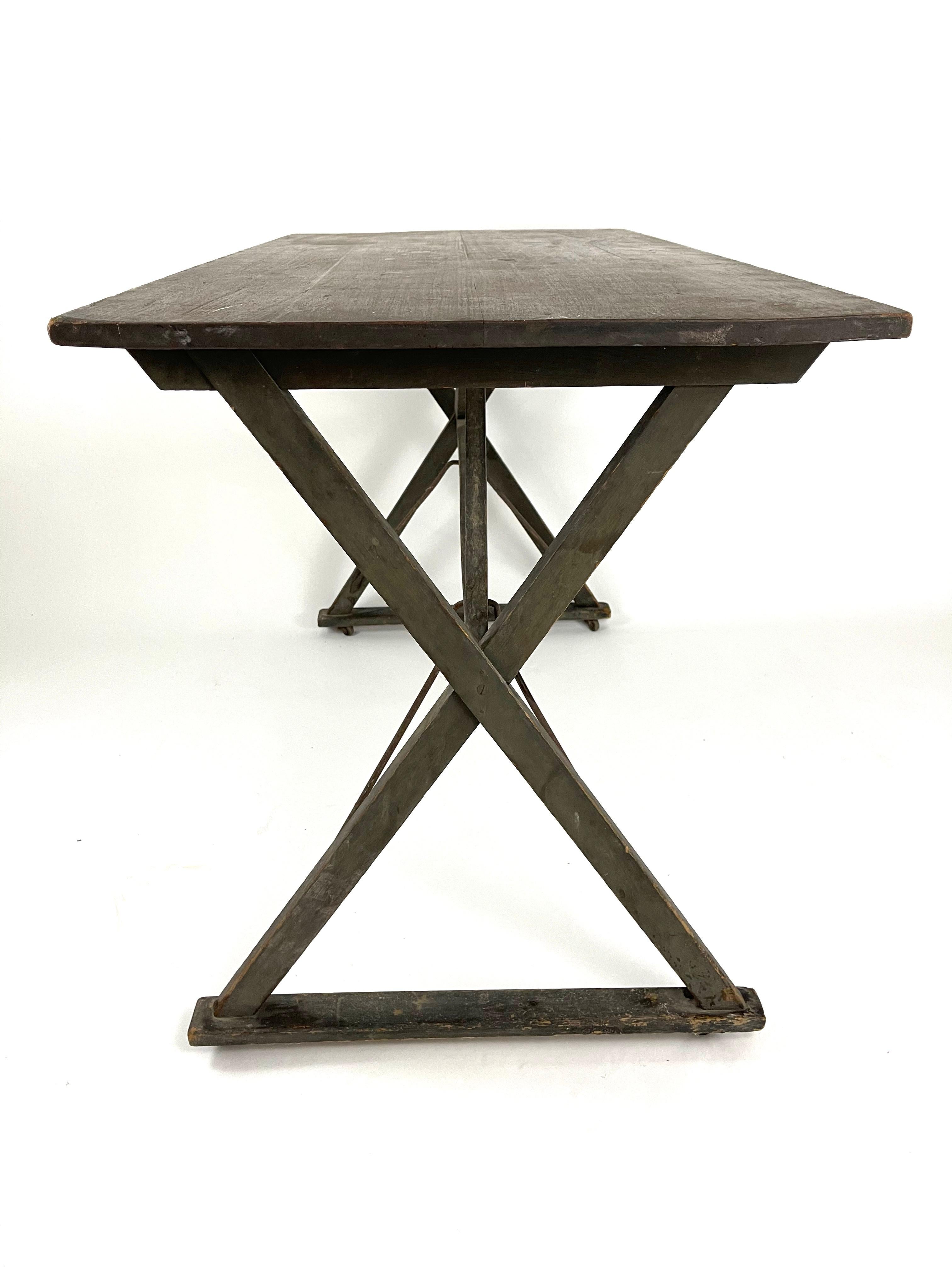 A 19th century American gray green panted poplar side table with a rectangular top supported by a sawbuck X-form base with iron brackets, joined by cross stretchers, retaining its original surface.

 

 