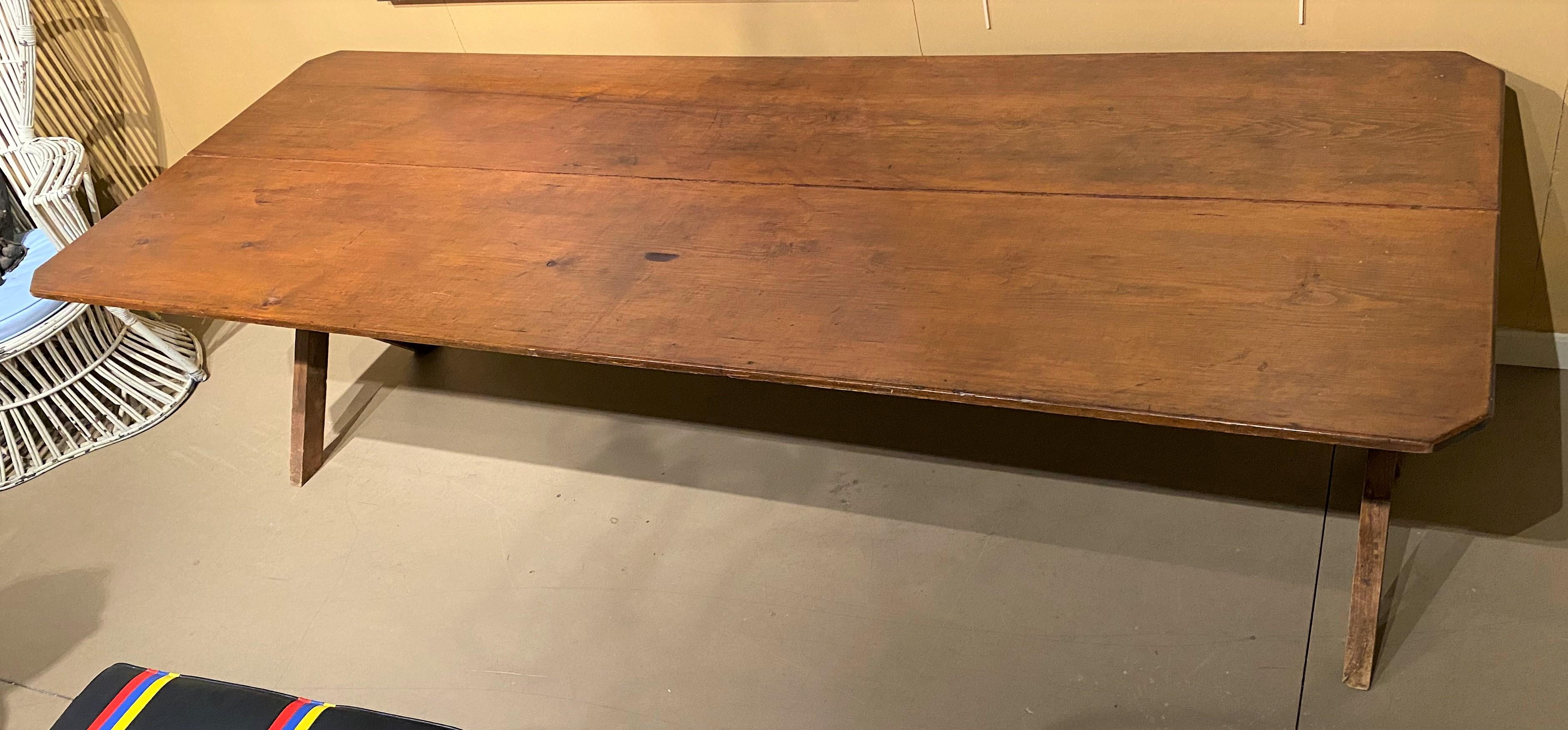 19th century American sawbuck trestle dining table with two board top. The top lifts off and the base can knock down. A great table for a country feast! With its ability to break down and be easily moved, it is also perfect to bring outside for al