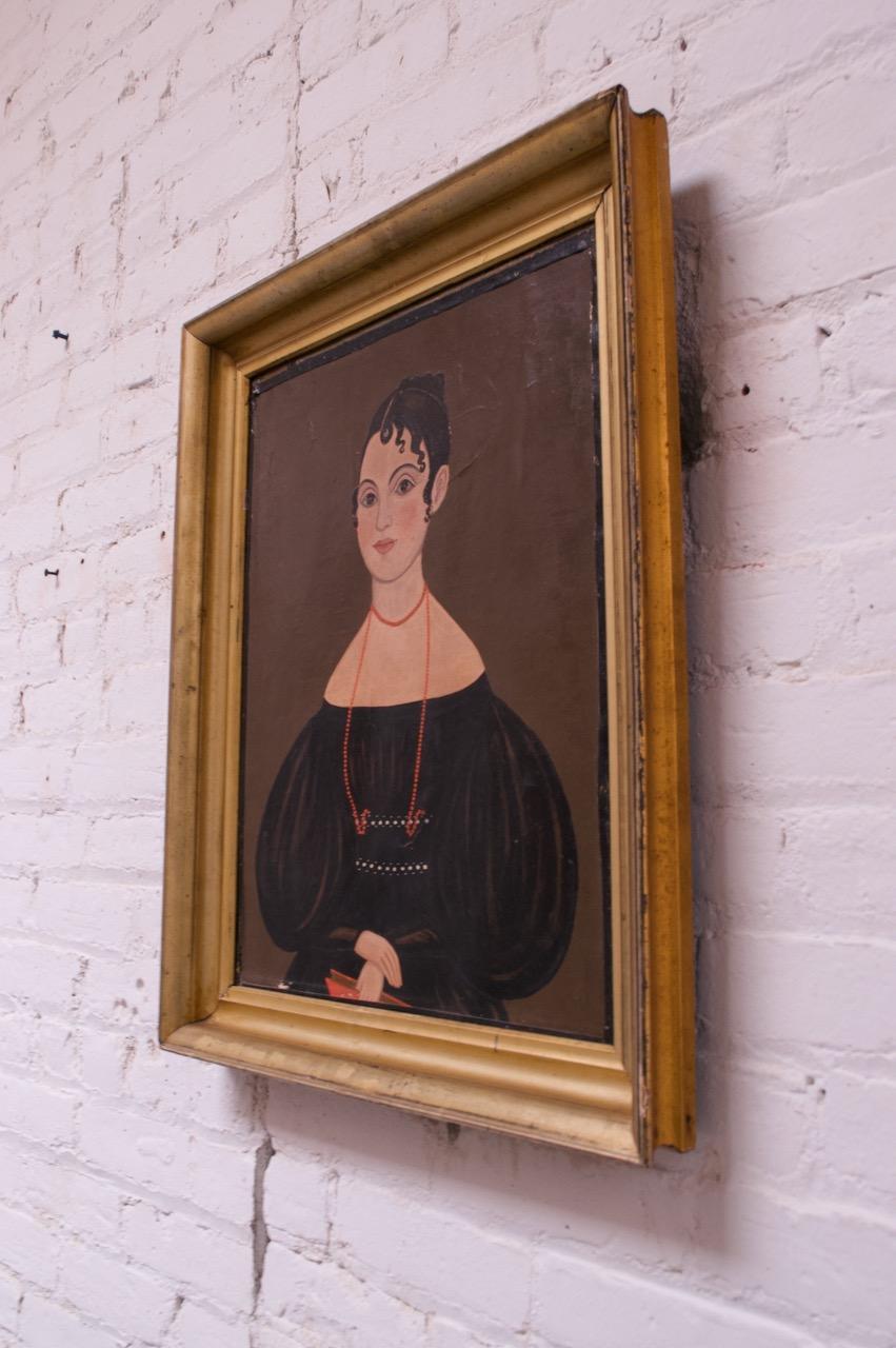 Folk Art oil painting depicting a seated lady, circa mid-late 19th century. Details like the exaggeratedly long neck are distorted, revealing a naive perspective. A nice period example in the folk art style.
Creases to the canvas, as shown. No
