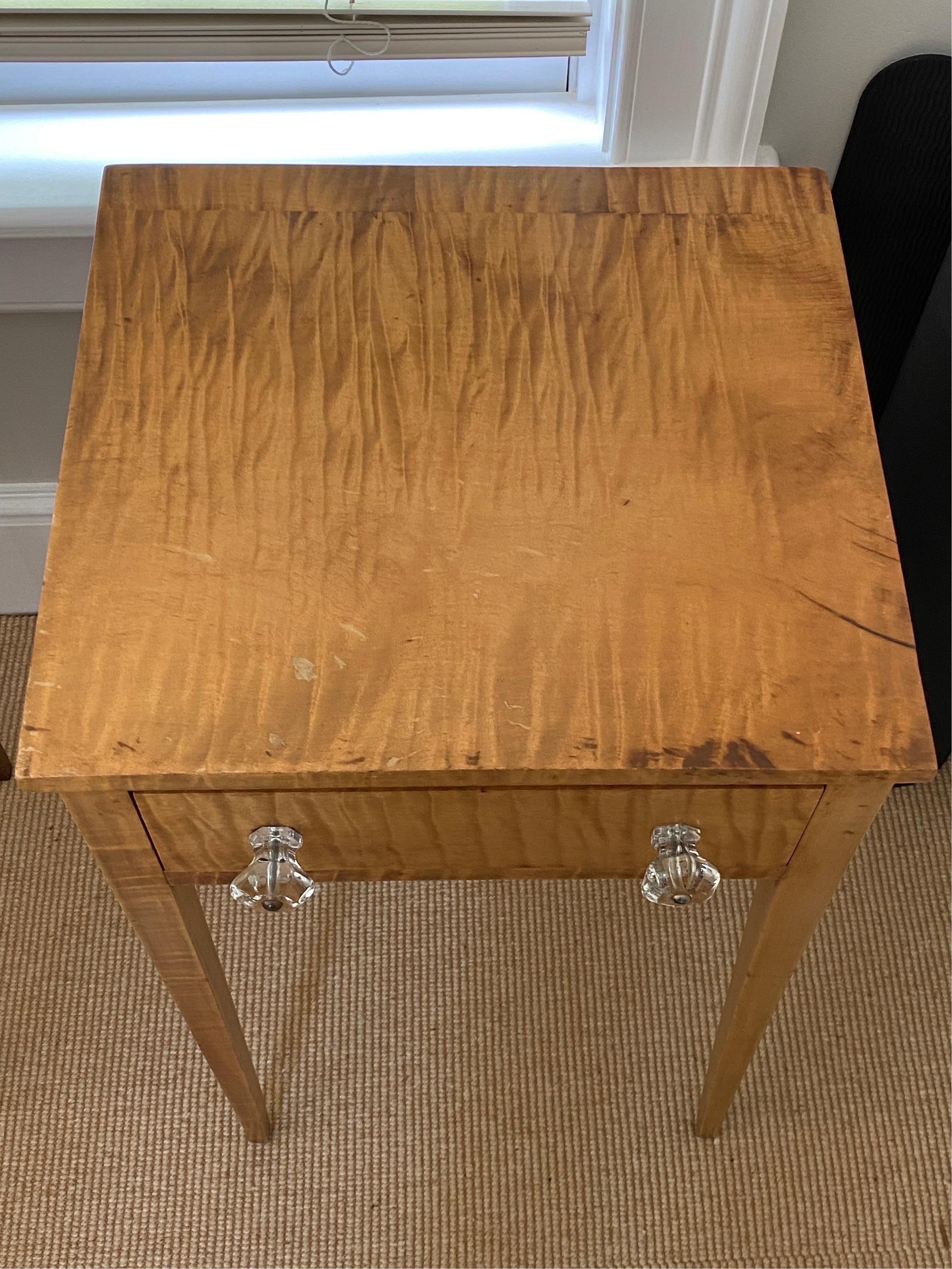 19th Century American sheraton tiger maple single drawer stand with glass knobs.
A lovely simple stand with beautiful wavy tiger maple grain and honey color finish. A single drawer with two glass knobs.
Measures: 15.66 wide x 15.25