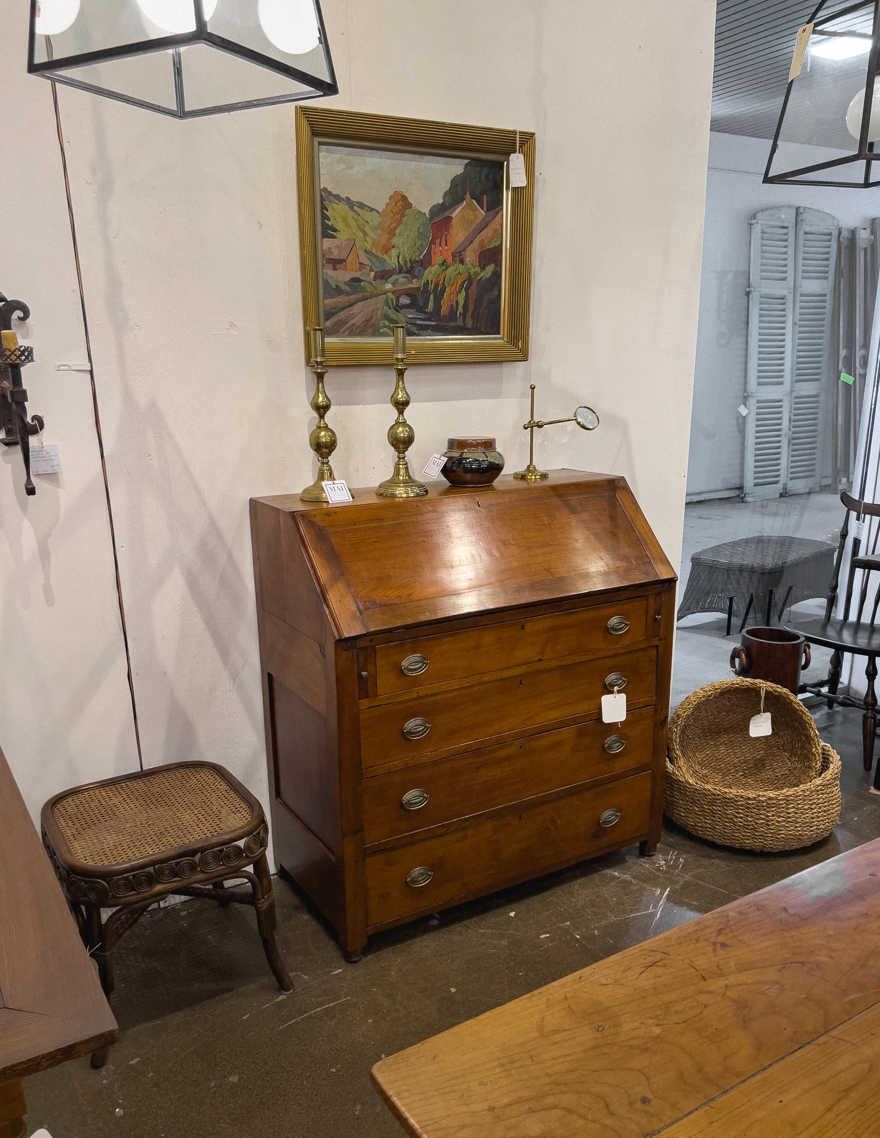 19th century American Slant Front Secretary made from mahogany and pine. The fall front desk is supported by 2 pull out slides, and the inside area contains multiple drawers and cubbies. Underneath there are 4 graduating drawers.
