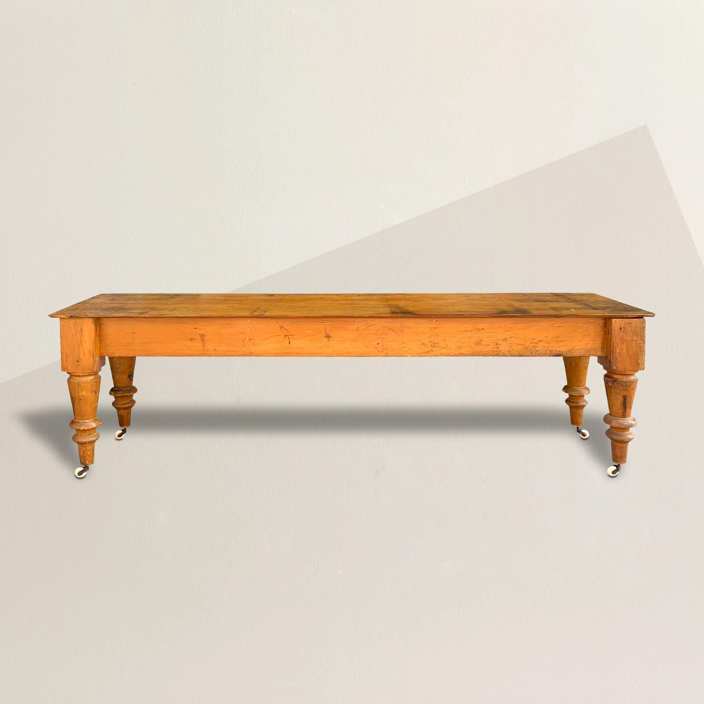 A wonderful 19th century American maple table, probably from a butcher's shop or bakery, with overly exaggerated chunky turned tapered legs with removable porcelain casters and a well worn top with one live-edge and one strait edge. Perfect for