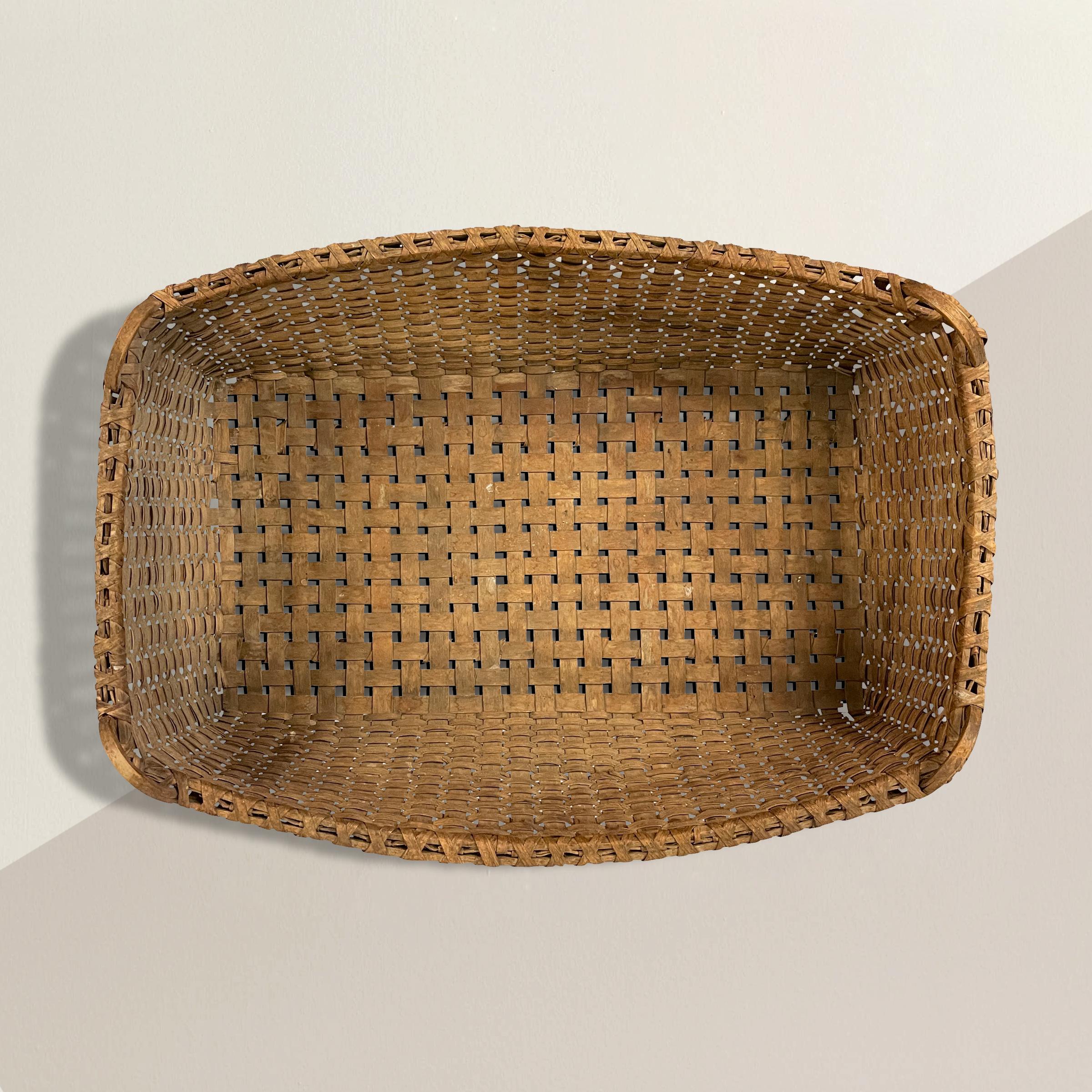 An incredible and rare 19th century American hand-woven oak-splint tobacco leaf basket with a bent-wood handle on each corner, wood runners on the bottom, and the most wonderful patina only time can bestow. Perfect for holding pillows and blankets