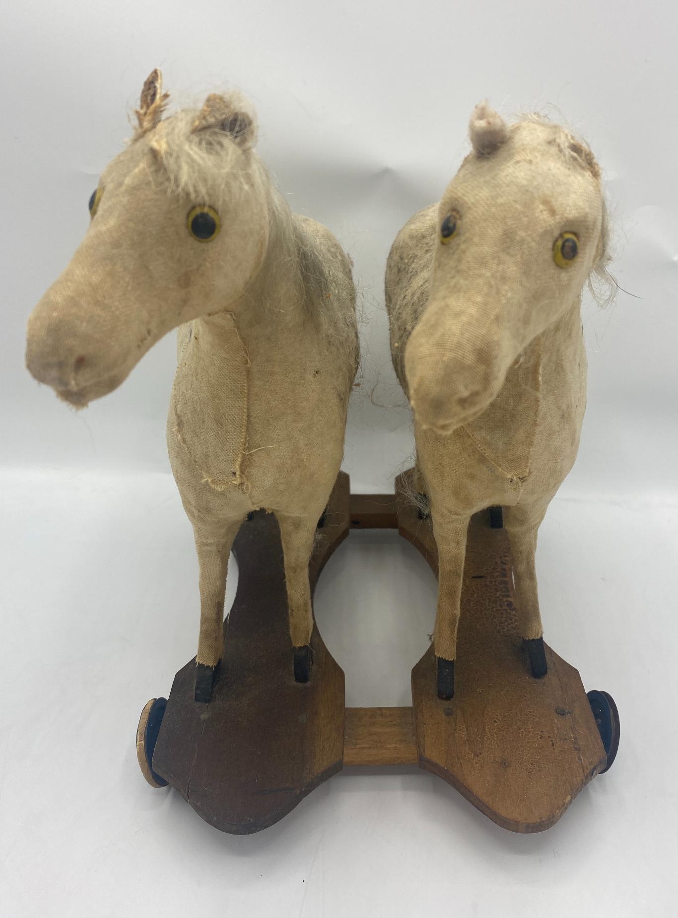 19th century American traditional children's dual horse pull toy
Made of fabric with wood planks with wheels
Measures: 10.25