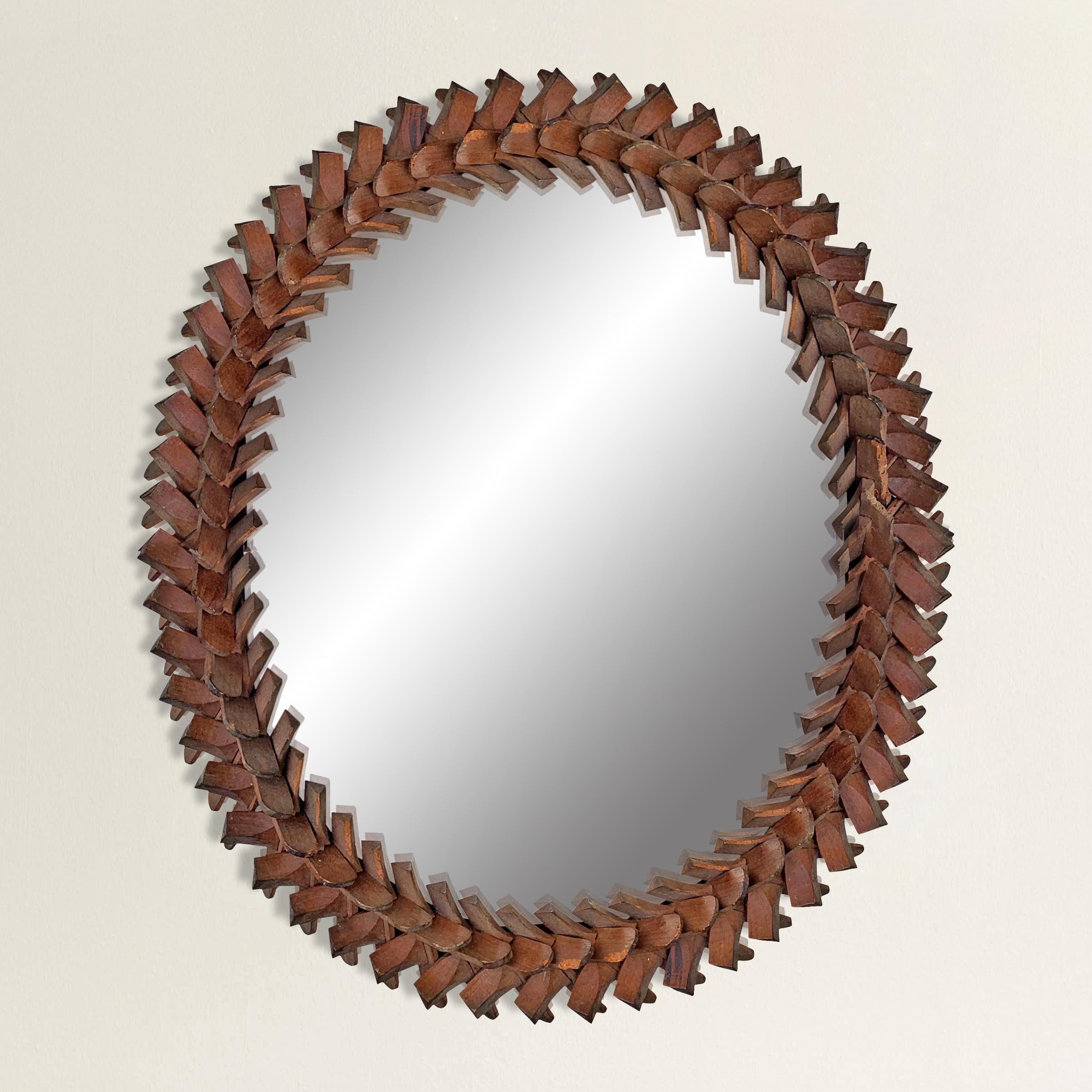 A whimsical 19th century American Folk Art Tramp Art oval framed mirror with a hand carved interlocking puzzle piece frame. Mirror can be hung vertically or horizontally.