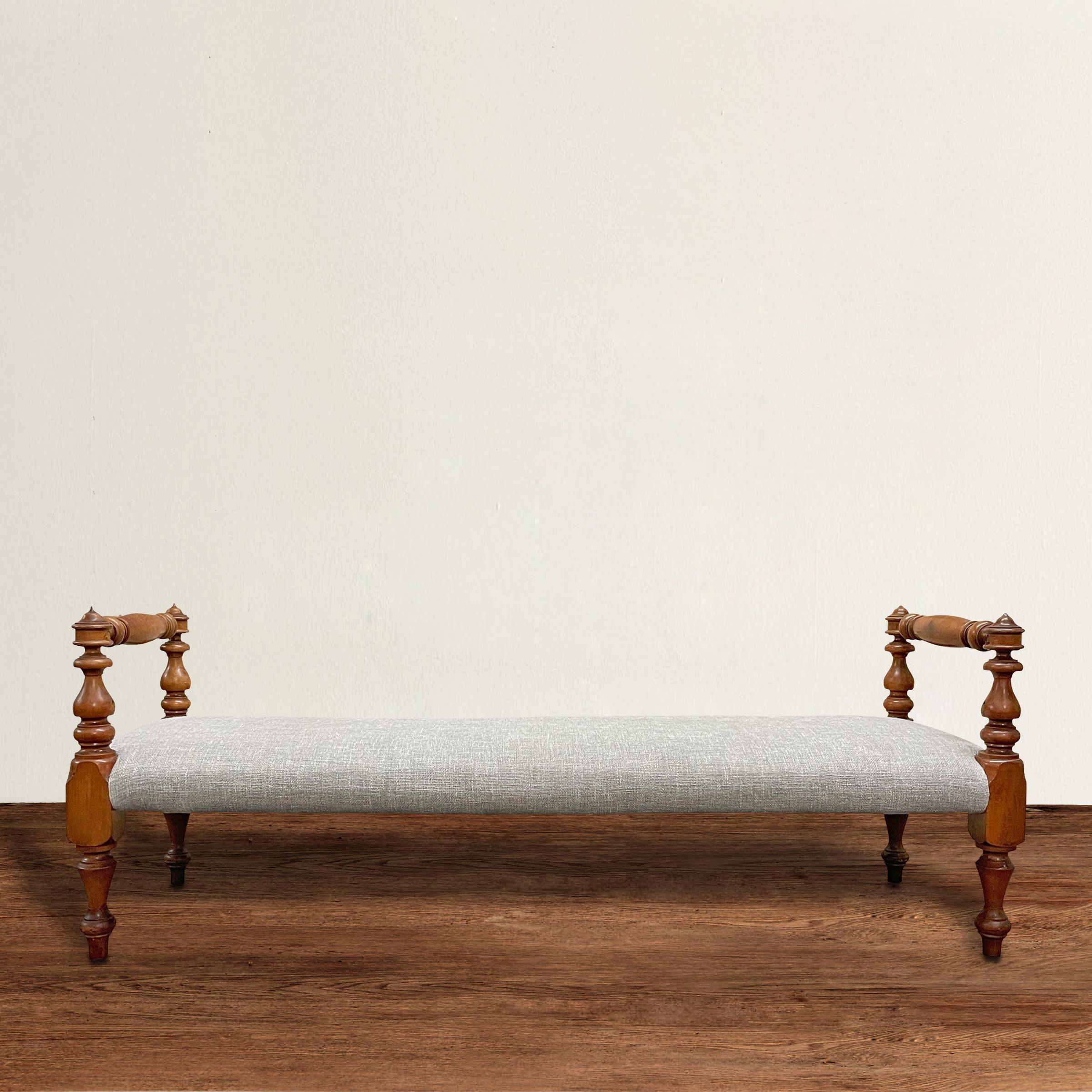 A wonderful mid-19th century American bench with turned maple arms, legs, and stretchers, and newly upholster in a chinky gray linen. Perfect at the end of a bed, in a hallway, or floating in your living room.