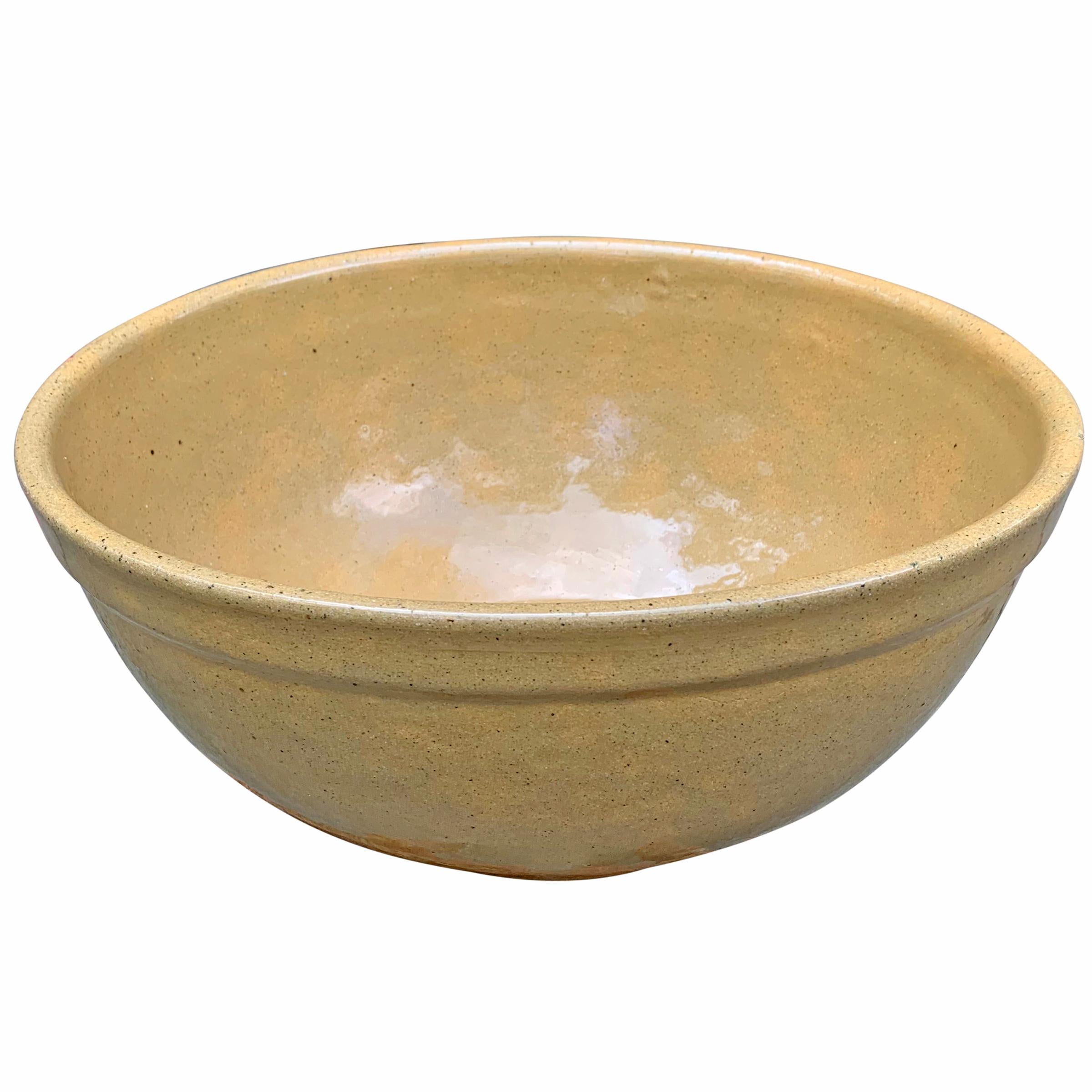 An incredible large 19th century American glazed yellowware mixing bowl with a fantastic scale perfect for mixing bread dough, cake batter, or serving a salad at your next gathering.