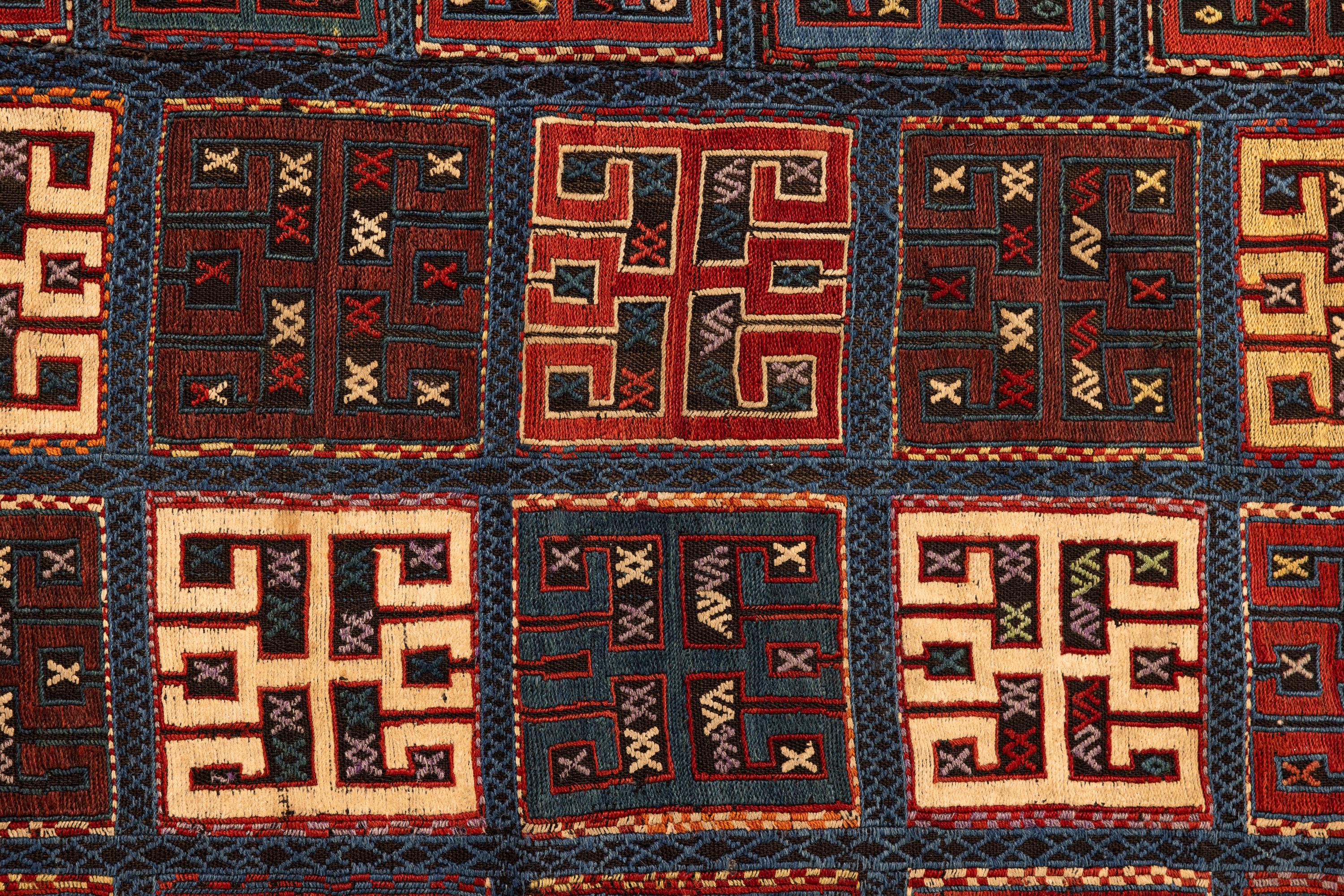 Verneh – Karabagh, South Caucasus
This high-quality Azerbaijani Verneh was woven using Soumak and brocade techniques on a dark-coloured base. With colourful geometric motifs, each of the 80 square compartments contains a large cruciform design with