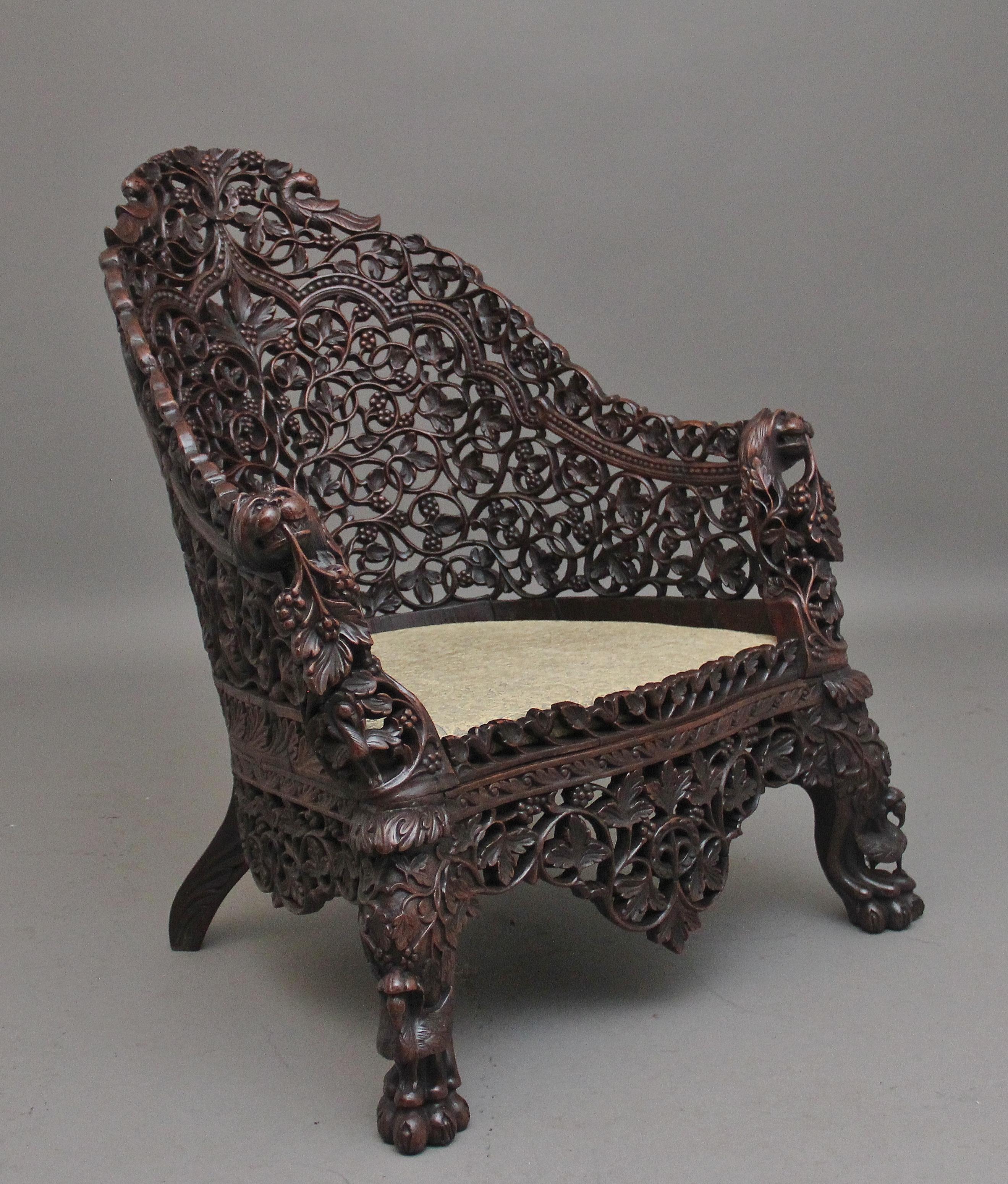 A superb quality 19th Century Anglo-Indian carved hardwood chair, profusely carved all over with carved fret decoration incorporating various birds and foliage, mythical figure heads on the arms, the bottom section having a nice carved shaped apron