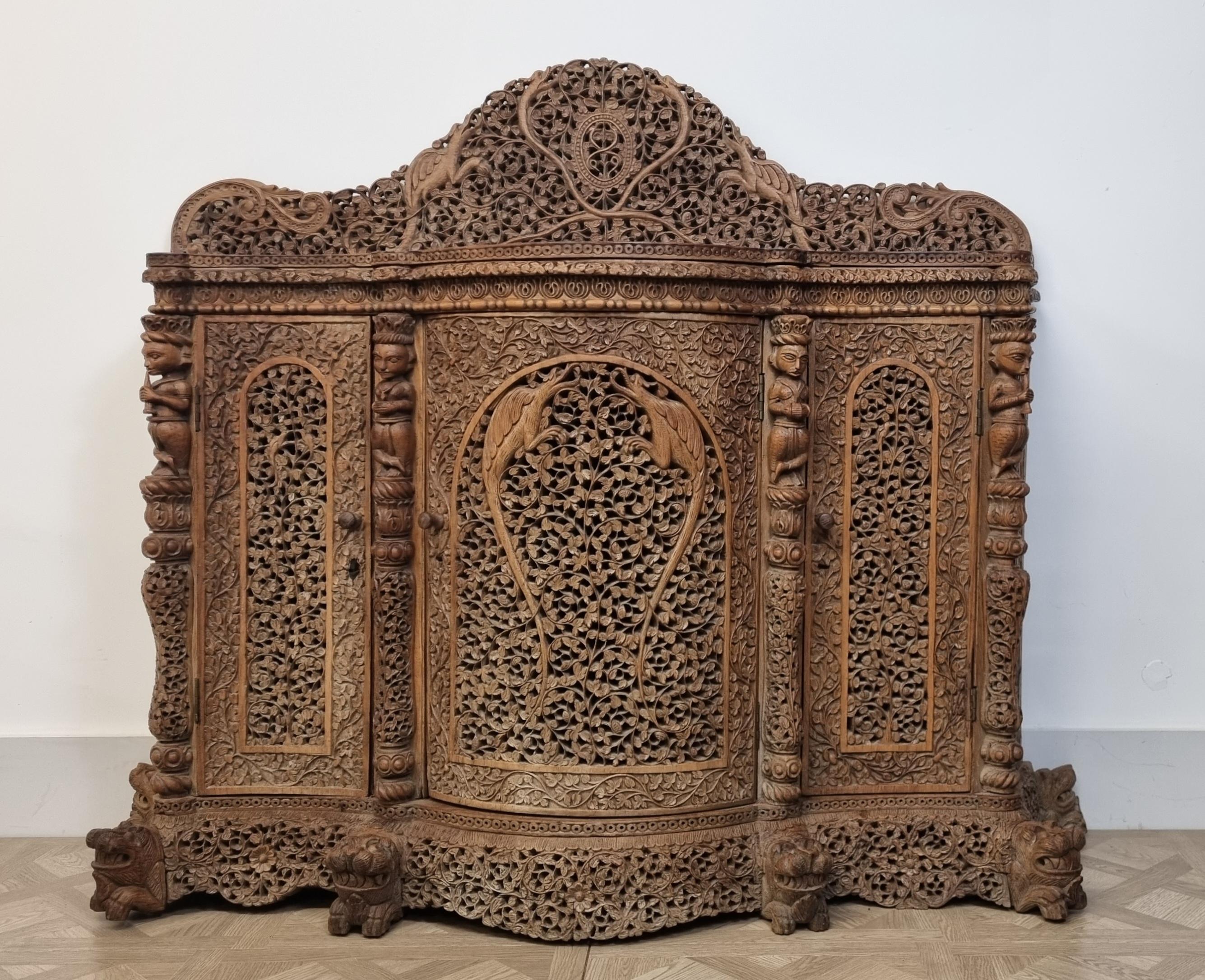 Exceptionnel meuble en bois dur anglo-indien du XIXe siècle, abondamment sculpté à la main avec un travail complexe de feuillage en spirale, de motifs floraux et de vignes. Le panneau central est finement décoré d'oiseaux exotiques au milieu d'un
