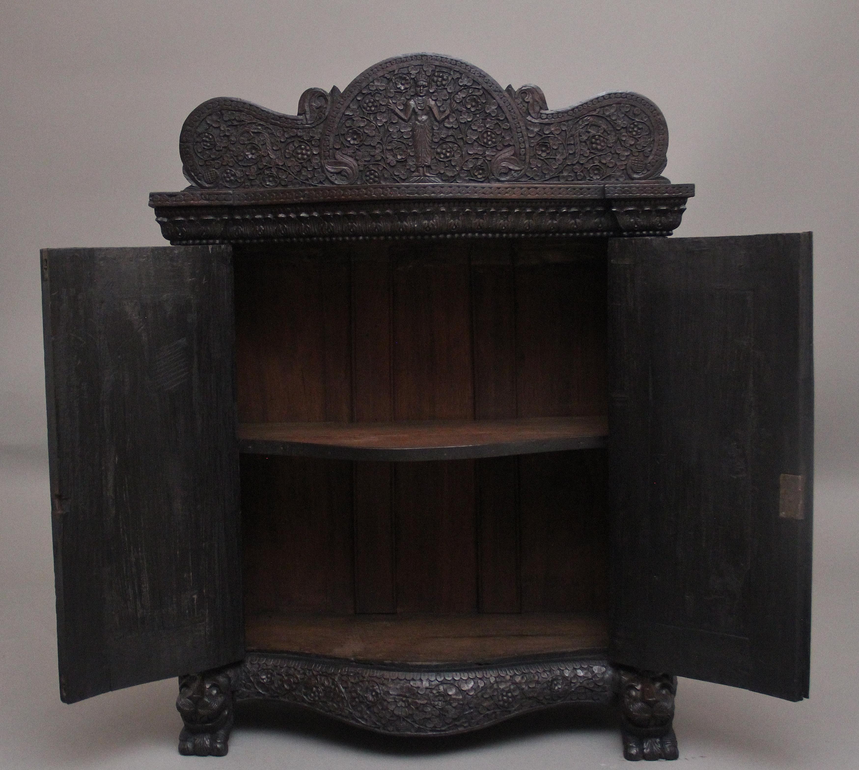 Armadio anglo-indiano in legno massiccio intagliato del XIX secolo di ottime proporzioni, con un bel piano sagomato e scolpito e un'alzata sagomata altamente decorativa con vari fogliami e figure mitiche al centro, il piano ha un intricato bordo