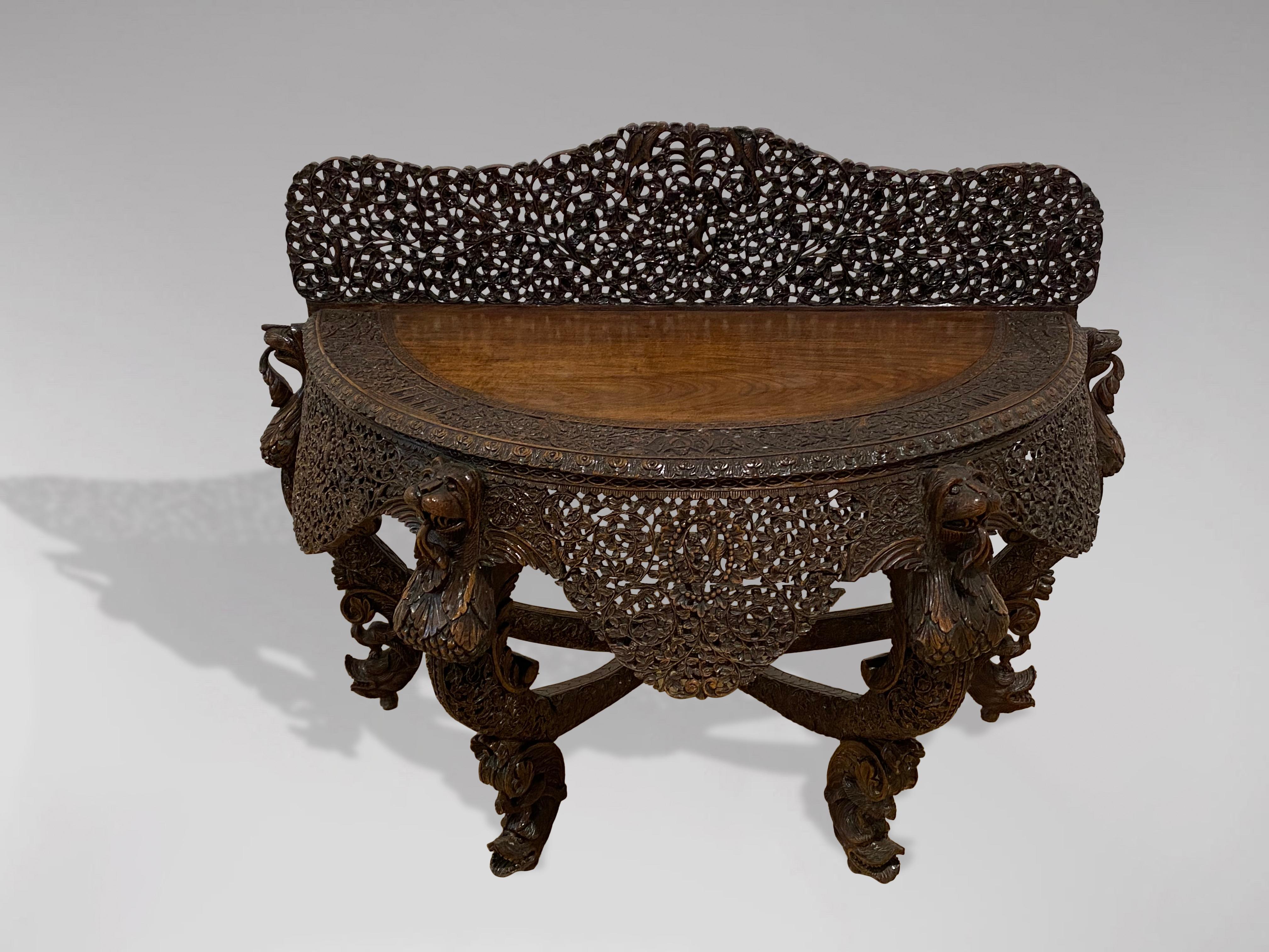 A mid 19th century beautiful and highly decorative British colonial rosewood console table supported by four profusely carved legs terminating into mythical animal faces at the table top. The top consists of a fine figured piece of rosewood and a