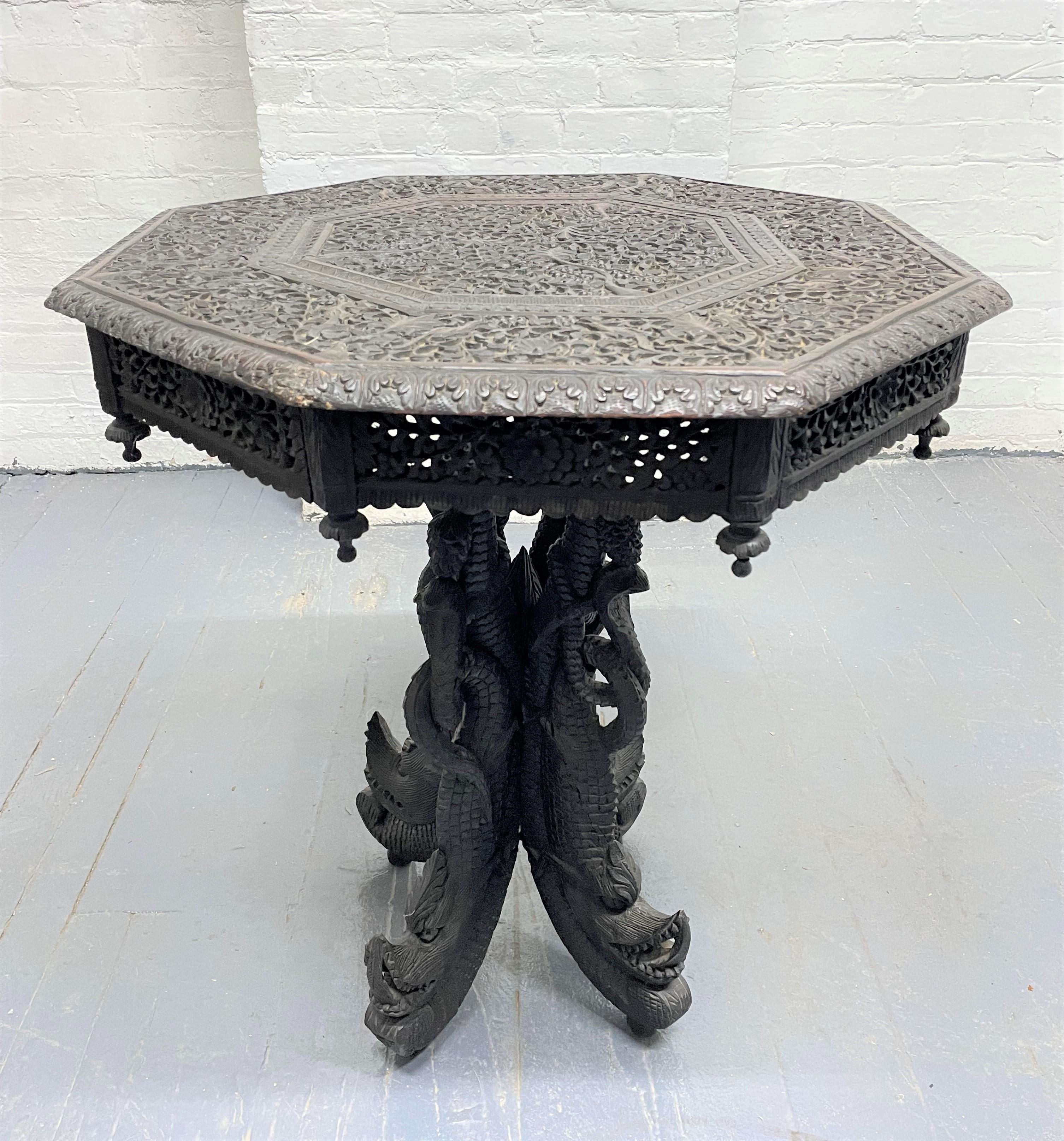 19th century Anglo-Indian carved wood table. The pedestal has rosewood carvings of rope and vine patterns and ravings of dragons.