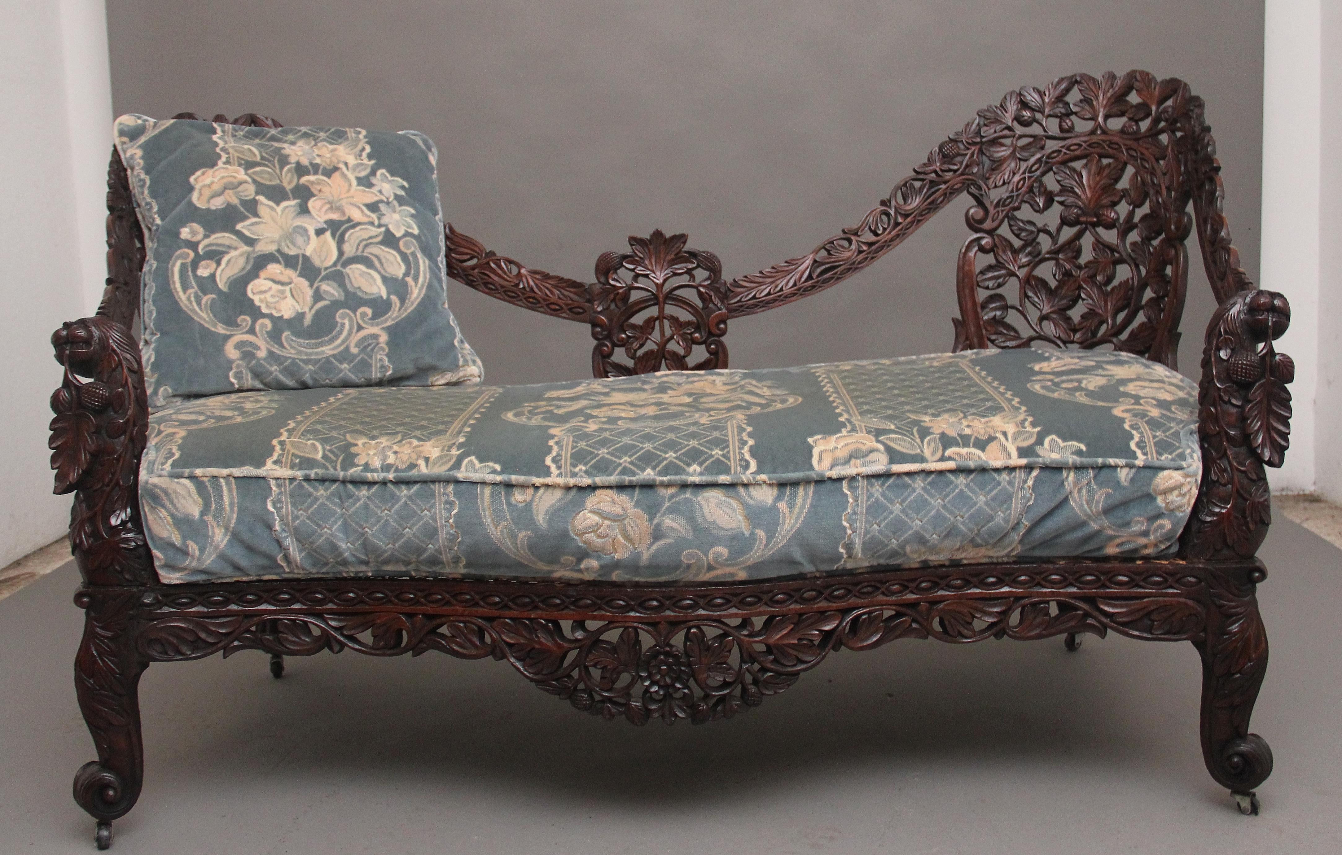 A superb quality 19th Century Anglo Indian carved sofa, the shaped back profusely carved with various foliage, the frame connecting down to the highly carved and decorative front supports incorporating mythical figure heads at each side, having a
