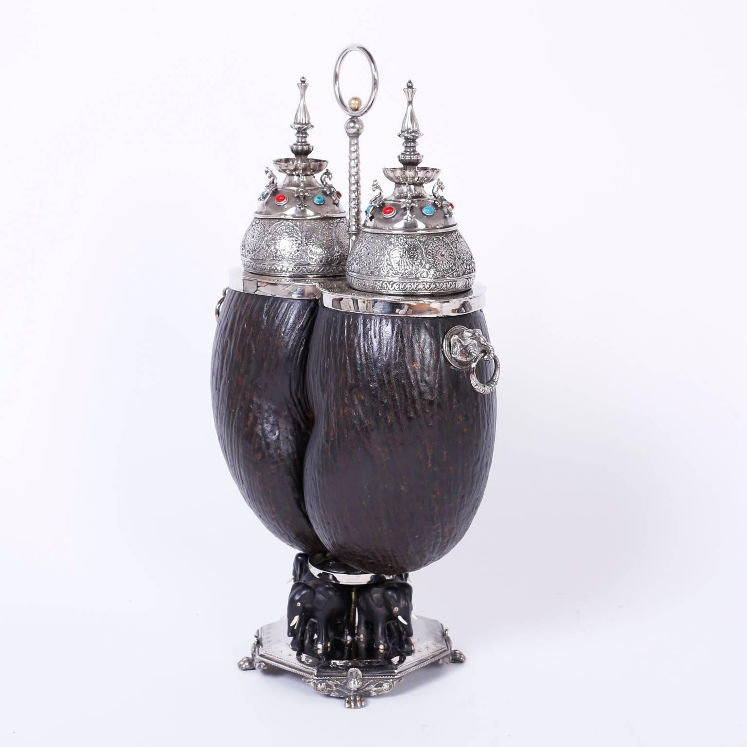 The coco de mer is rare double lobe nut from the Seychelles Islands with mystical properties. This example is now a luxurious tea caddy that has silver metal lids with exotic finials, hand-hammered floral designs, phoenix birds, semi precious stones