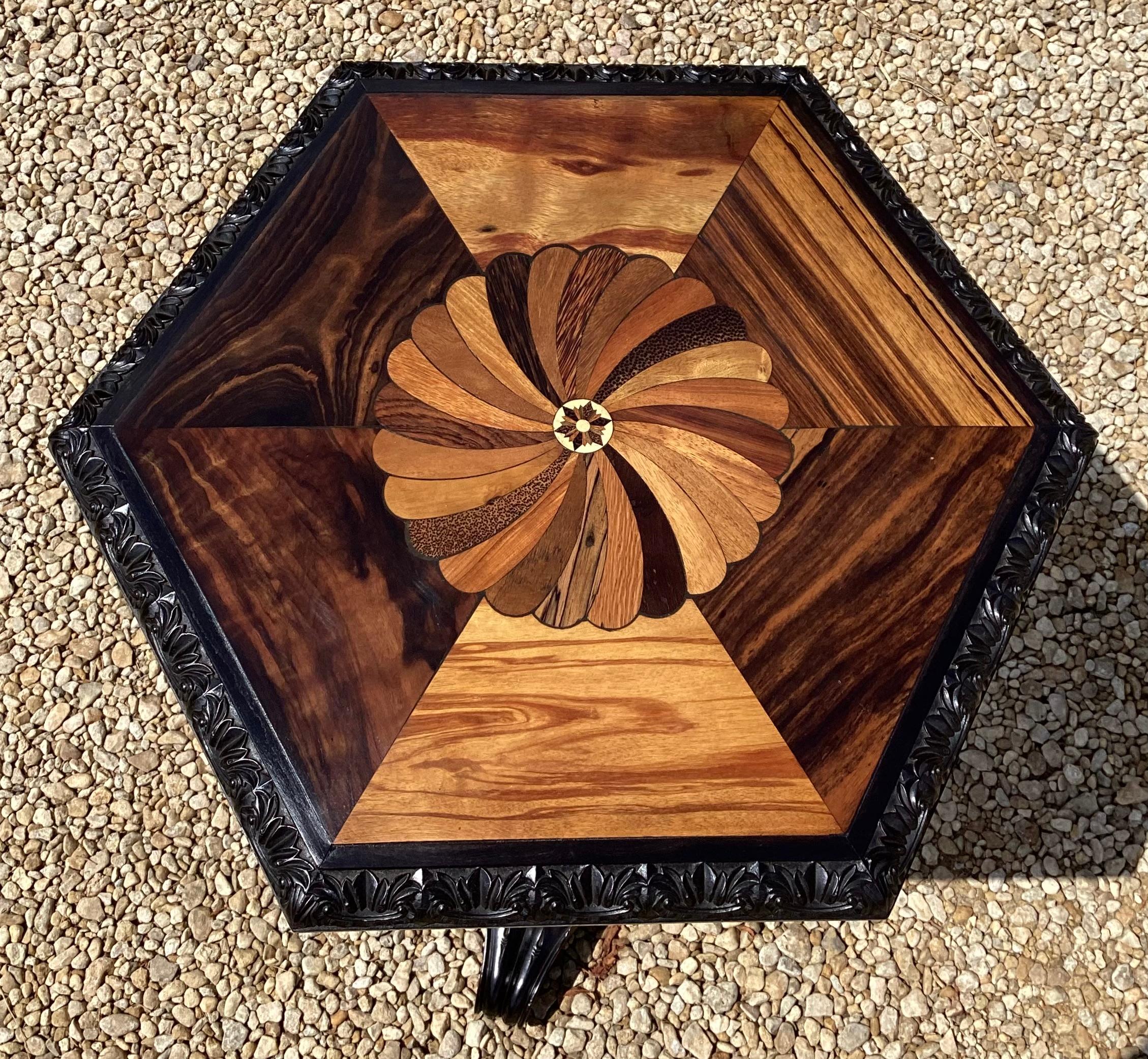 A smart early C19th Ceylonese Ebony occasional table, the specimen inlaid hexagonal top centred by a swirl of exotic woods including Palm, Satinwood, Coromandel and Palisander. With a roundel to the centre with further inlay. All surrounded by a