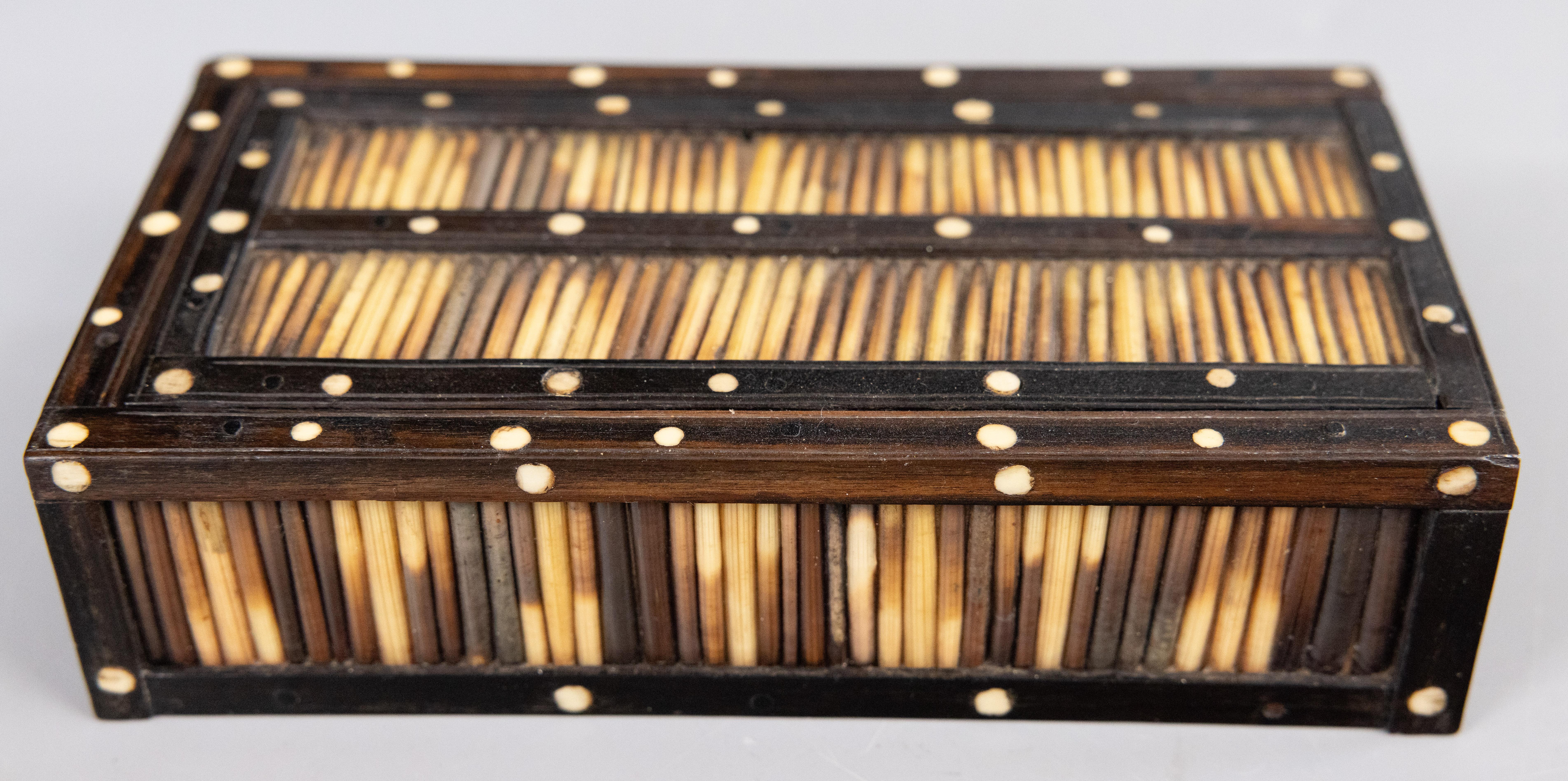 Fina caja de ébano y púa de puercoespín de la época colonial británica del siglo XIX, fabricada en Ceilán, nombre colonial de Sri Lanka. Esta fina caja artesanal tiene tapa corredera y está decorada con púas rodeadas por un marco de ébano. Base