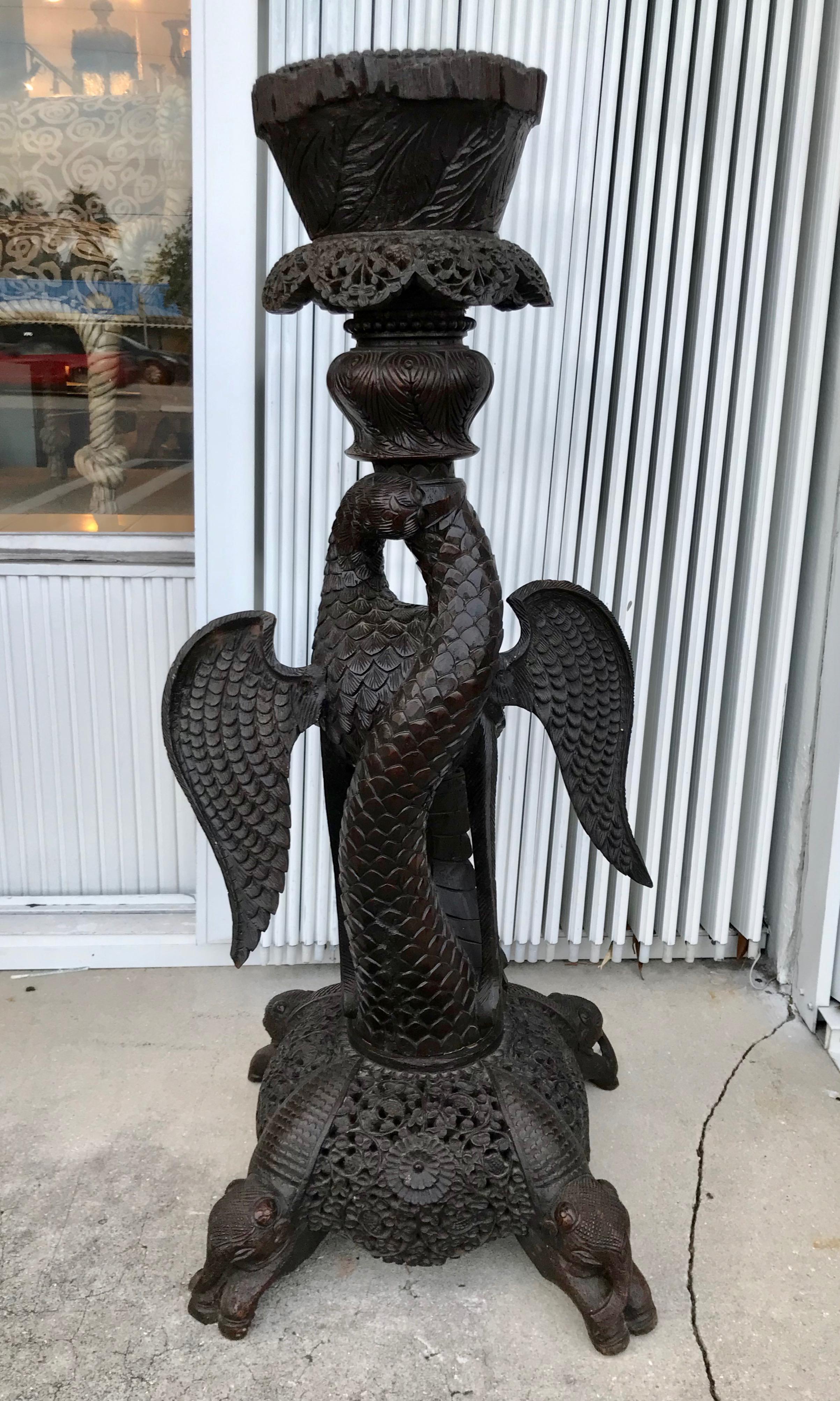 La pièce est minutieusement sculptée et représente un aigle avec un serpent dans la bouche.
Il repose sur une base qui se termine par quatre pieds à motif d'éléphant.
Fabuleuse sculpture en bois dur.