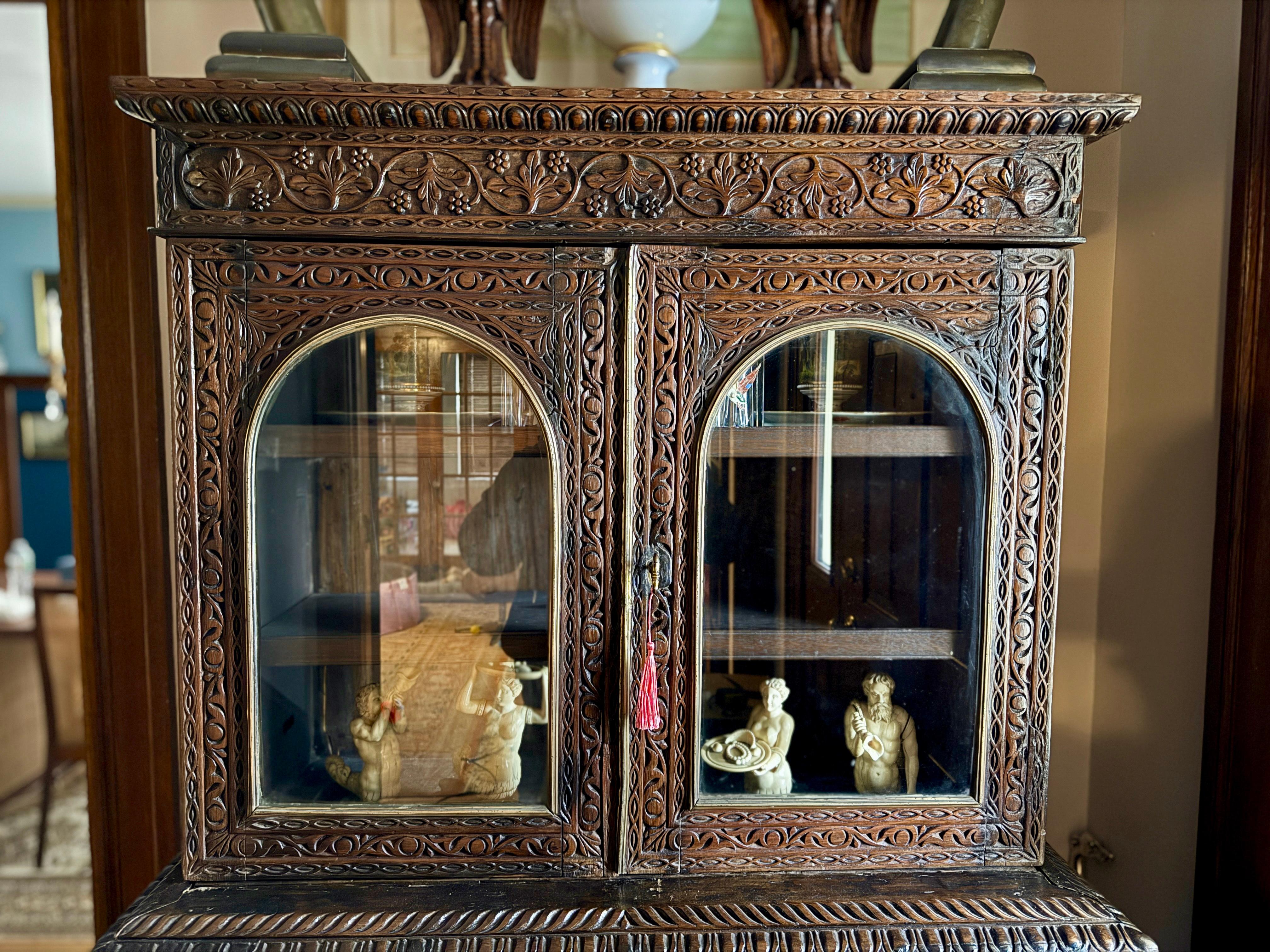This 19th-century Anglo-Indian campaign secretary bookcase (in 3-parts) is an extraordinary example of colonial-era craftsmanship, rendered in richly grained rosewood and heavily adorned with intricate carvings. The upper section features two